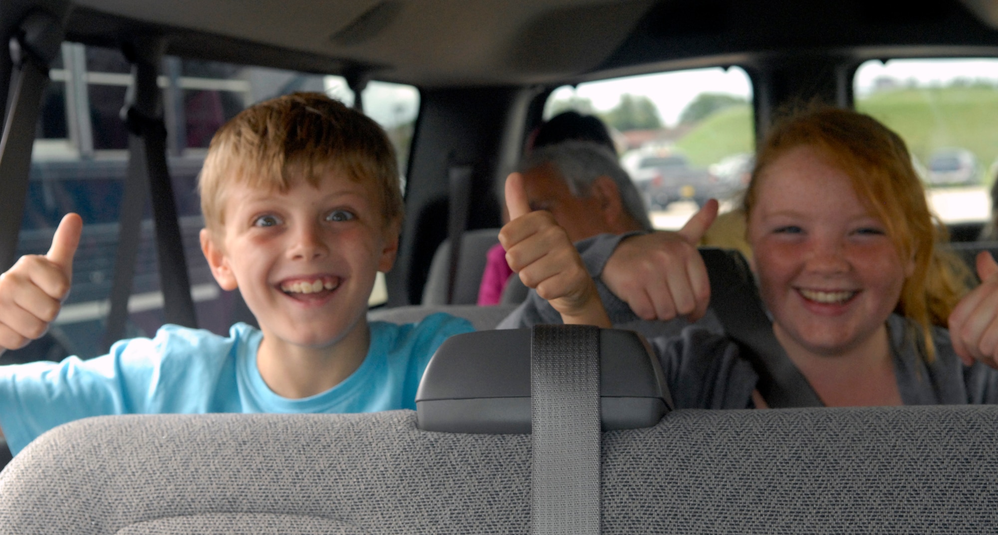 Billy Harris, 9-year-old son of 100th Civil Engineer Squadron customer services representative Patricia Harris, and his friend 10-year-old Bethany Higgins of Bury St. Edmunds, give a thumbs up as their tour bus begins to roll out for a one-hour guided tour of RAF Mildenhall Aug. 21, 2010. The bus tour was also only a small part of the 100th CES's open house where hundreds of British Nationals were invited to attend.  (U.S. Air Force photo/Tech. Sgt. Kevin Wallace)