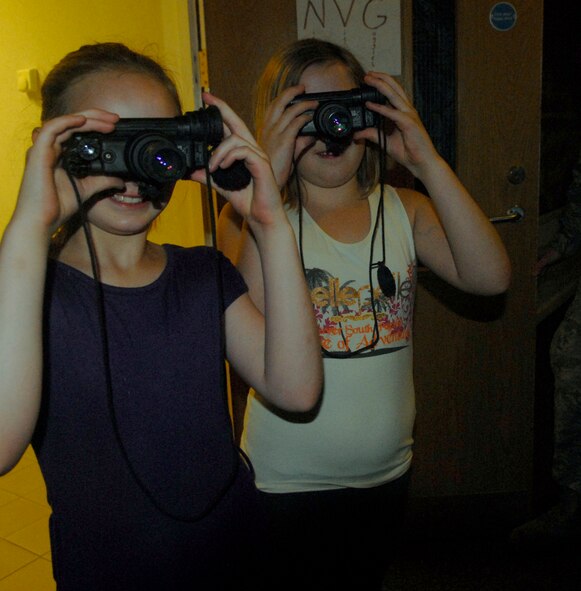 Faith and Brianne Funkhouser try on a pair of night vision goggles during the 100th Civil Engineer Squadron open house Aug. 21, 2010. The 9- and 11-year-old girls said they loved the display. (U.S. Air Force photo/Tech. Sgt. Kevin Wallace)