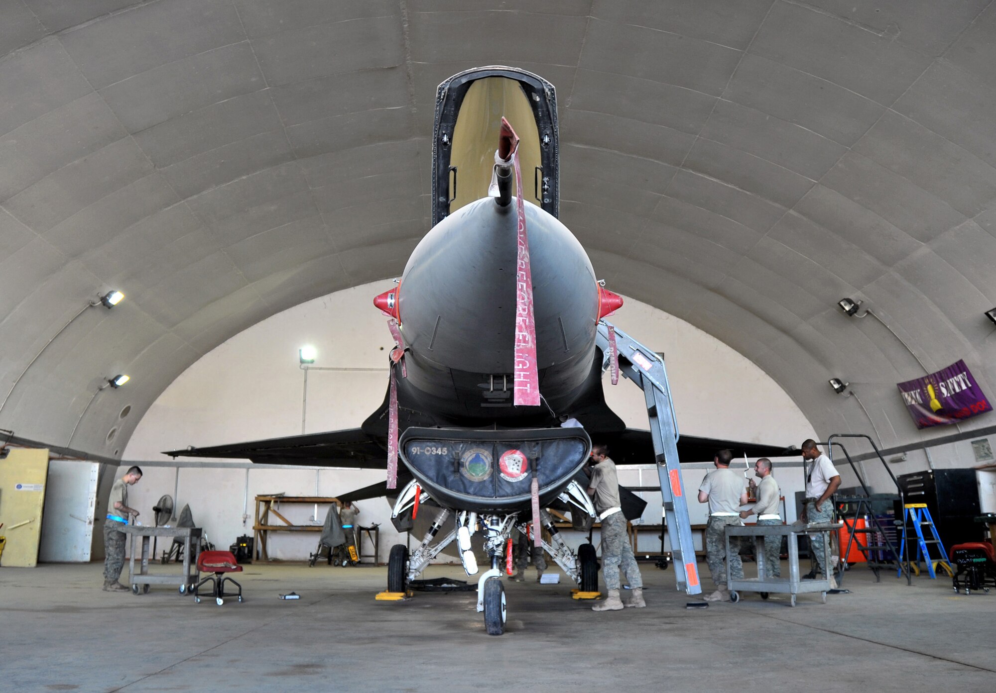 Aircraft mechanics of the 332nd Expeditionary Maintenance Squadron Phase Inspection Section reassemble an F-16 Fighting Falcon in a hardened aircraft shelter during a 400-hour phase inspection Aug. 9, 2010 at Joint Base Balad, Iraq. Phase inspections are thorough programs of preventative maintenance and inspection performed on the multi-role fighter jets every 400, 800 and 2,400 flying hours. The Airmen and the aircraft are deployed from Shaw Air Force Base, S.C. (U.S. Air Force photo/Lt. Col. Robert Couse-Baker)