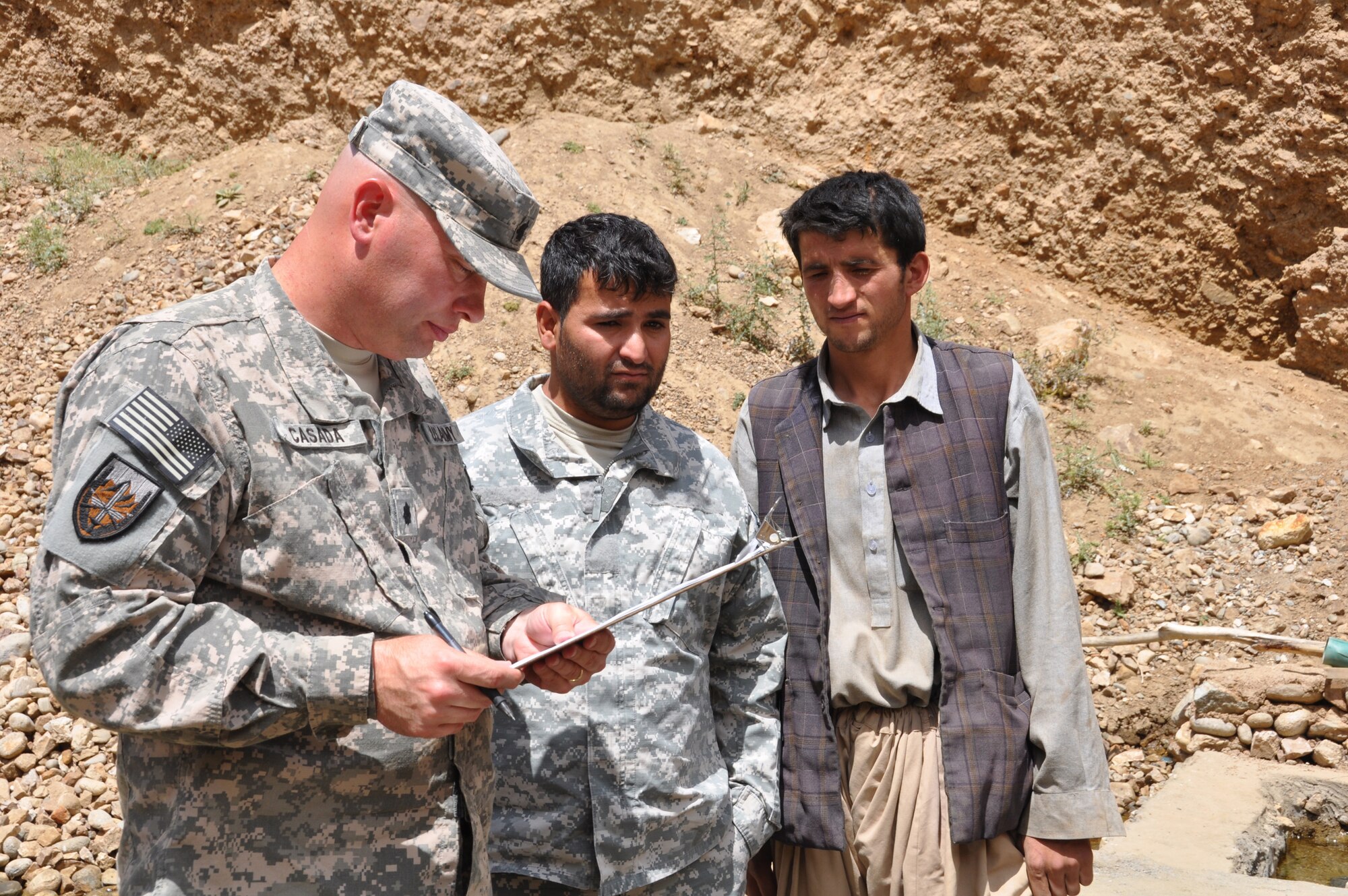 U.S. Army Lt. Col. Jeffrey Casada, Kentucky National Guard Agribusiness Development Team leader with Provincial Reconstruction Team Panjshir and London, Ky., native, helps a Paryan District fish farmer, Abdul Aziz, fill out an application for a micro grant. The grant allows private business owners to apply for up to $10,000 in funding. The Kentucky National Guard ADT with PRT Panjshir is teaming up with the local entrepreneur to educate him on modern techniques and expand his business. (Photo by U.S. Air Force 1st Lt. Holly Hess, PRT Panjshir Public Affairs)