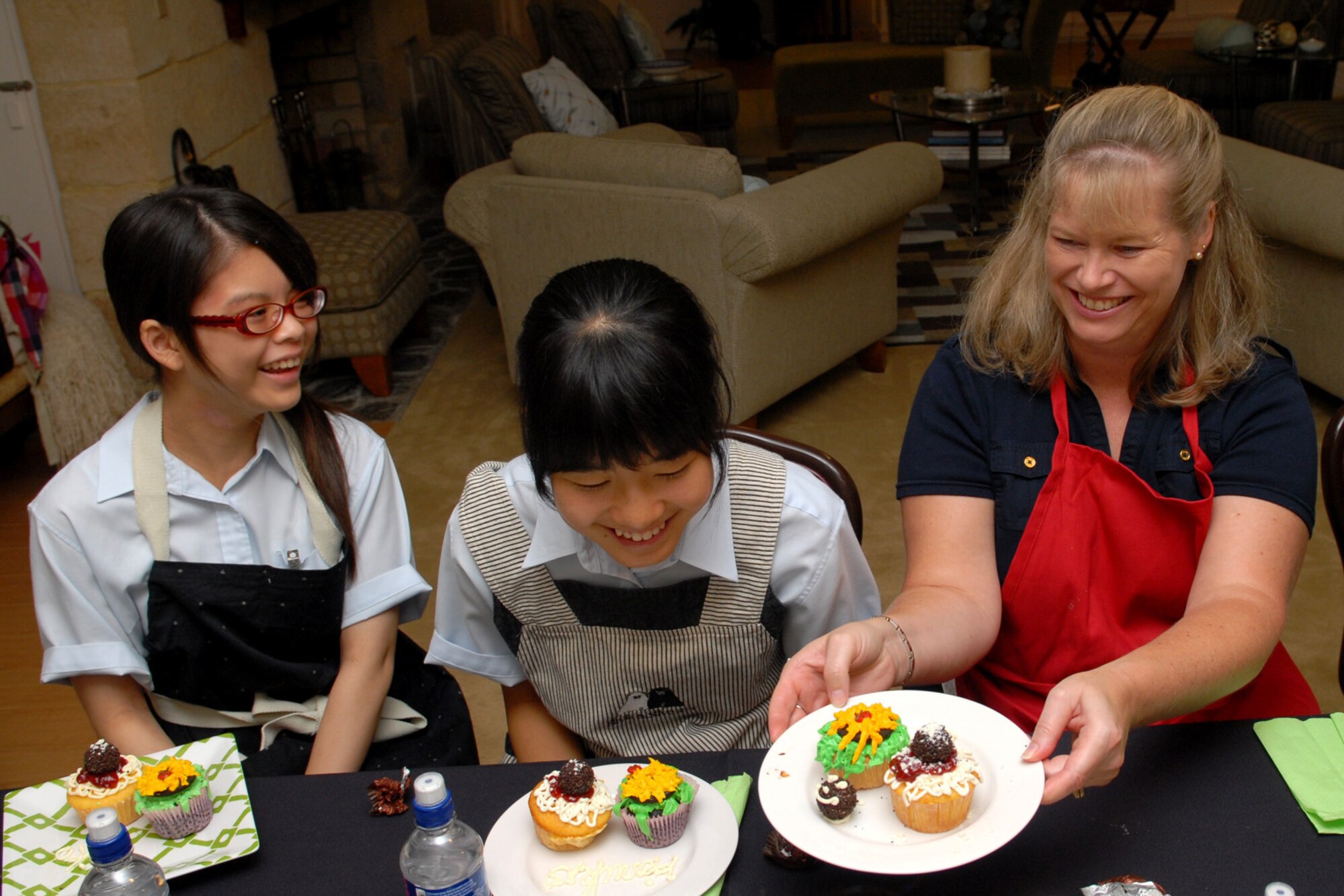 Mrs. Charlotte Rupp, spouse wife of Col. Ricky Rupp, Vice Commander, 18th Wing vice commander, shows Yuriko Uehara and Haruka Toume  cupcake- decorating techniques at Kadena Air Base, Aug. 18. Students from the Junior and Senior High School Affiliated to Showa Pharmaceutical University attended the event at the home of Brig. Gen. Ken Wilsbach, 18th Wing commander, and were hosted by Mrs. Cindy Wilsbach. 
(U.S. Air Force Photo/Junko Kinjo)