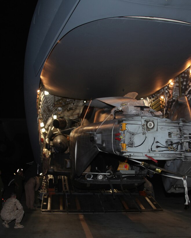 Marines from Marine Heavy Helicopter Squadron 361, 3rd Marine Aircraft Wing (Forward) monitor a CH-53E Super Stallion from Marine Medim Tiltrotor Squadron 266 (Reinforced), 26th Marine Expeditionary Unit,  as it is unloaded from an Air Force C-17 Globemaster III cargo plane Aug. 22. HMH-361 Marines aided VMM-266 (Rein) Marines with the unloading process.