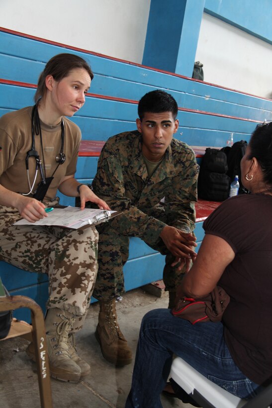 German Navy Cmdr. Diana Seemann and Lance Cpl. Daniel I. Huerta, native of Glendale, Ariz., and motor technician serving as a Spanish translator from Company A, 2nd Assault Amphibian Battalion, Ground Combat Element of Special-Purpose Marine Air Ground Task Force Continuing Promise 2010, talk to a Costa Rican woman about her medical issues in a high school gymnasium in Bribri, Costa Rica, Aug. 23. Marines, sailors and USS Iwo Jima personnel are ported in Limon, Costa Rica, providing medical, dental, veterinary, community relations and engineering services to Costa Ricans as part of the CP10 mission during their deployment to the Caribbean, Central and South America.