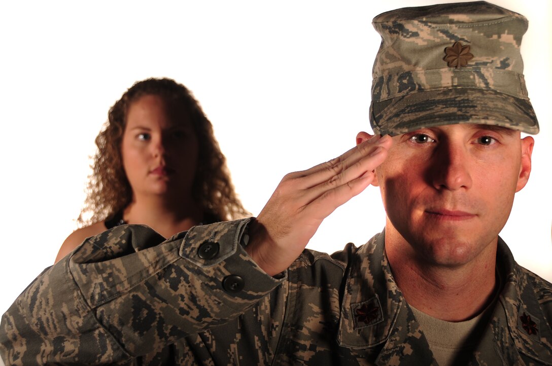 ELLSWORTH AIR FORCE BASE, S.D. – Maj. Erik Dunn, 28th Comptroller Squadron commander salutes while his wife, Deanna, stands behind him, Aug. 18.  Mrs. Dunn is a key spouse who focuses on the Heart Link program. Heart Link's objective is to increase spouse awareness of the 28th Bomb Wing mission, as well as Air Force customs, traditions, protocol and community resources which support Air Force families. (U.S. Air Force photo/ Senior Airman Corey Hook)