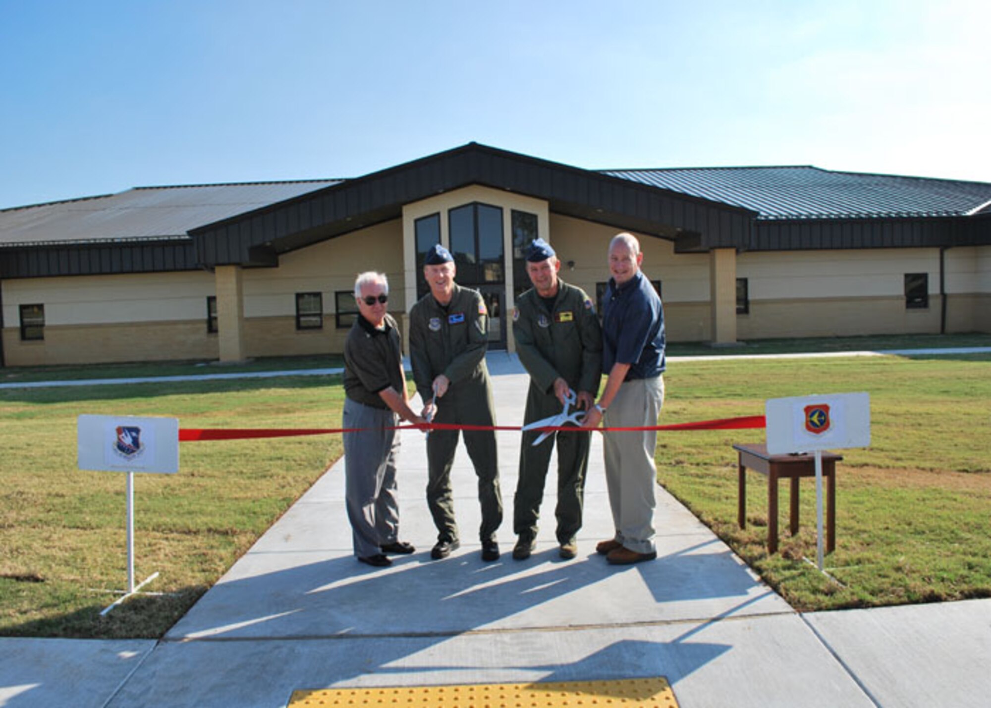 Mr. Ralph Homesley (left), Col. Gregory Ferguson, 137th Air Refueling Wing commander (Oklahoma Air National Guard), Col. Jeffery Glass, 507th Air Refueling Wing commander and Mr. Warren Ross cut the ribbon to officially open the consolidated Operations Building August 19. Homesley is with Office Interiors of Oklahoma C ity, Okla., who helped furnish the building.  Ross is the owner of the Ross Group, the general contractors for the building. The building had been under construction since June 2008 and will house operations offices from both wings.
