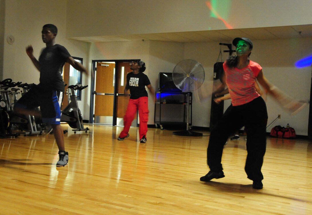 ELLSWORTH AIR FORCE BASE, S.D. -- (Right to left) Tech. Sgt. Bayyinah Sharif, Air Force Financial Services Center relocation section chief, Ken Oliver, Air Force Financial Services Center contractor and Airman Kymon Carriker, 28th Logistics Readiness Squadron vehicle operator, dance to up-beat music during an exercise dance class, Aug. 20.  Combined with cardio workout and a mix of different dance techniques, this exercise class was exciting for all in attendance. (U.S. Air Force photo/Airman 1st Class Anthony Sanchelli)