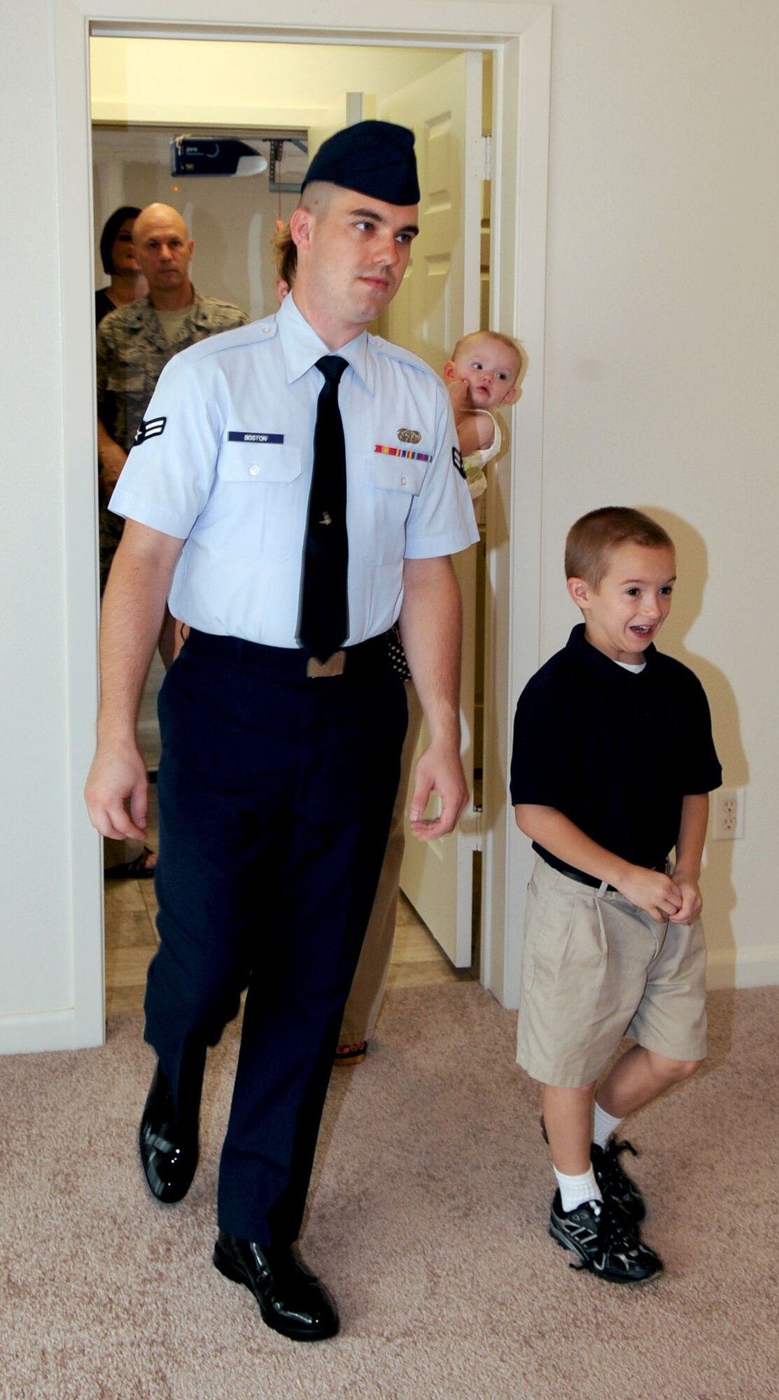 BARKSDALE AIR FORCE BASE, La. -- Airman 1st class Gary Boston and six-year-old son Gary Boston Jr., walks into their new home for the very first time Aug. 18. The Boston family is one of 97 families to move into the newly built duplex homes located in Liberty Heights on the East Reservation of base. (U.S. Air Force photo by Senior Airman La'Shanette V. Garrett) (RELEASED)