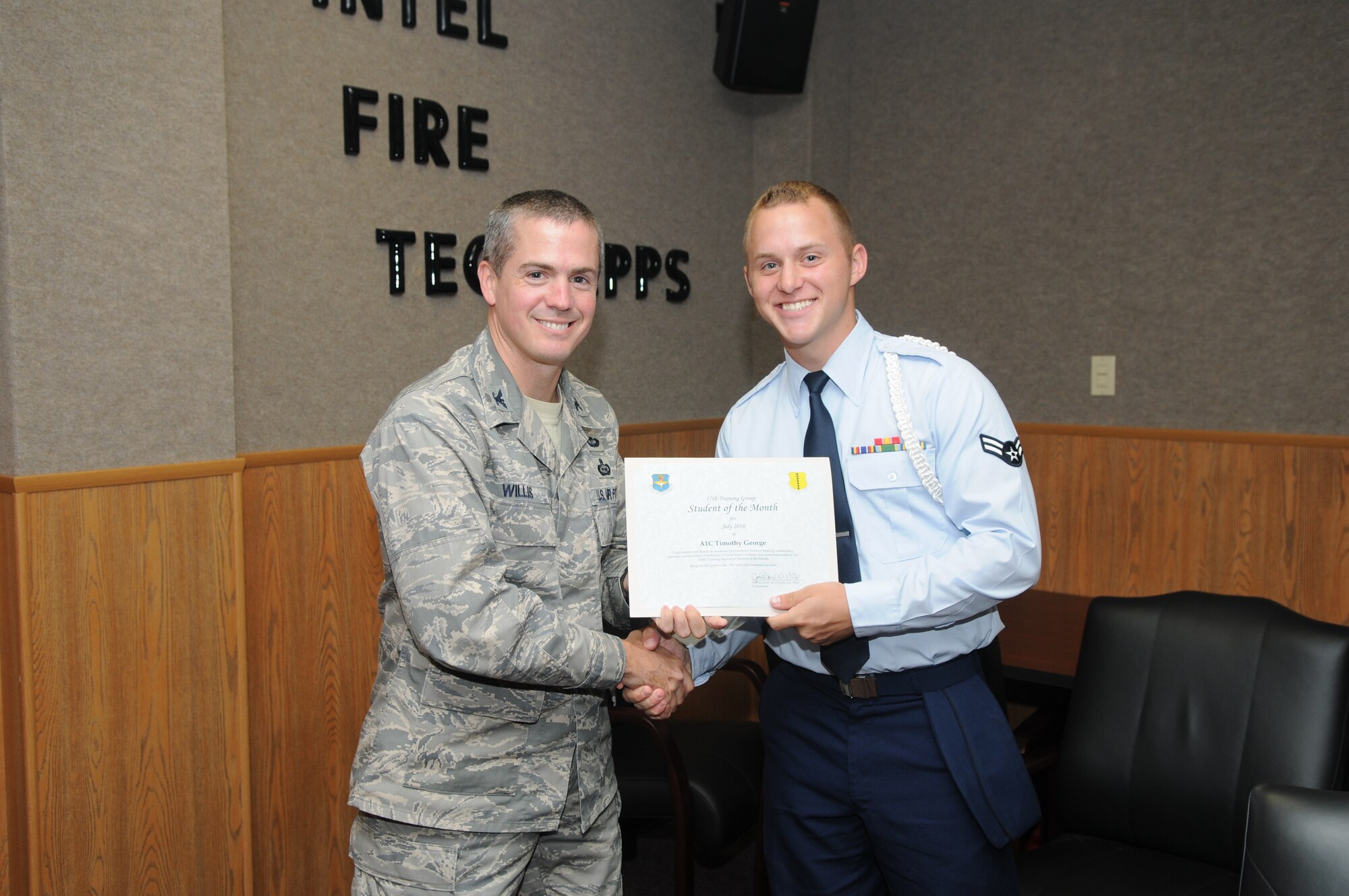 Airman 1st Class Timothy George, 316th Training Squadron, accepts his July Student of the Month award from Col. J.D. Willis, 17th Training Group commander. (U.S. Air Force photo/Airman 1st Class Clayton Lenhardt) 