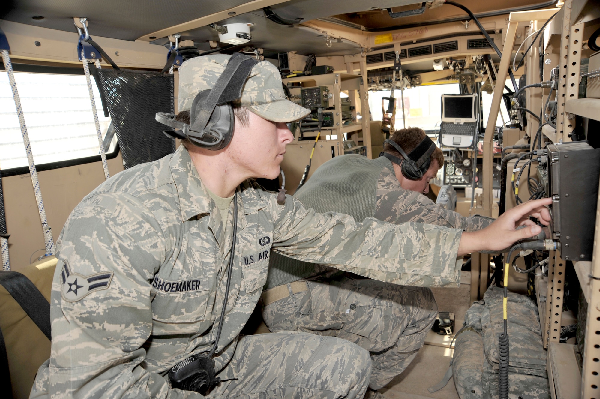 Senior Airman Donald McKee and Airman 1st Class John Shoemaker check radio equipment inside their mine-resistant ambush-protected vehicle Aug. 3, 2010, at Camp Liberty, Iraq. Airmen McKee and Shoemaker are from the 82nd Air Support Operations Squadron, Det. 2. ( U.S. Air Force photo by Senior Airman Perry Aston)