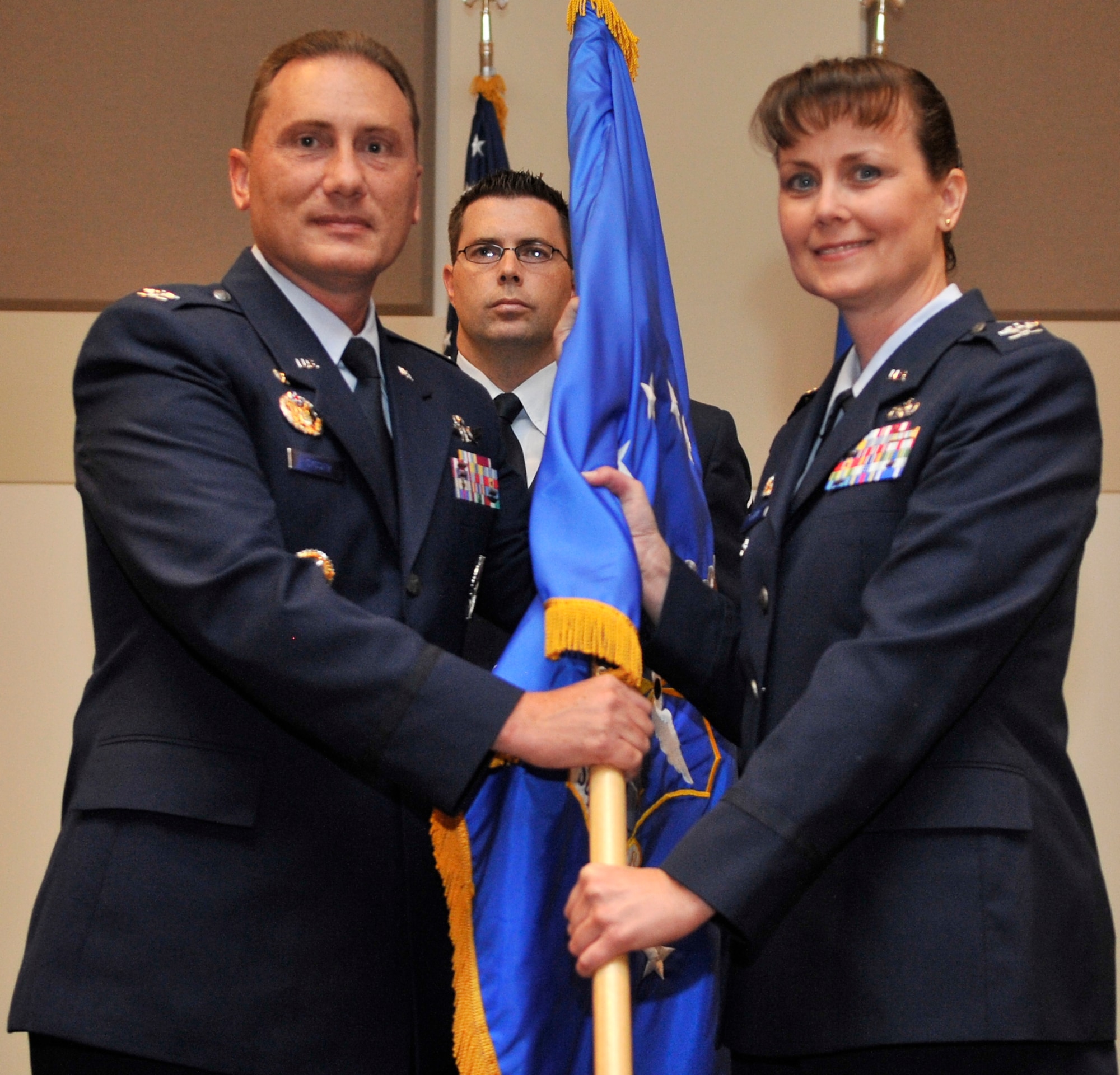 Col. Clint Crosier, 460th Space Wing commander, passes the 460th Mission Support Group flag to Col. Deirdre Mahon as she assumes command of the group Aug. 16. Colonel Mahon comes to Buckley Air Force Base from the Defense Logistics Agency headquarters at Fort Belvoir, Va., where she served as the chief of the distribution operations division. (U.S. Air Force photo by Airman 1st Class Paul Labbe)
