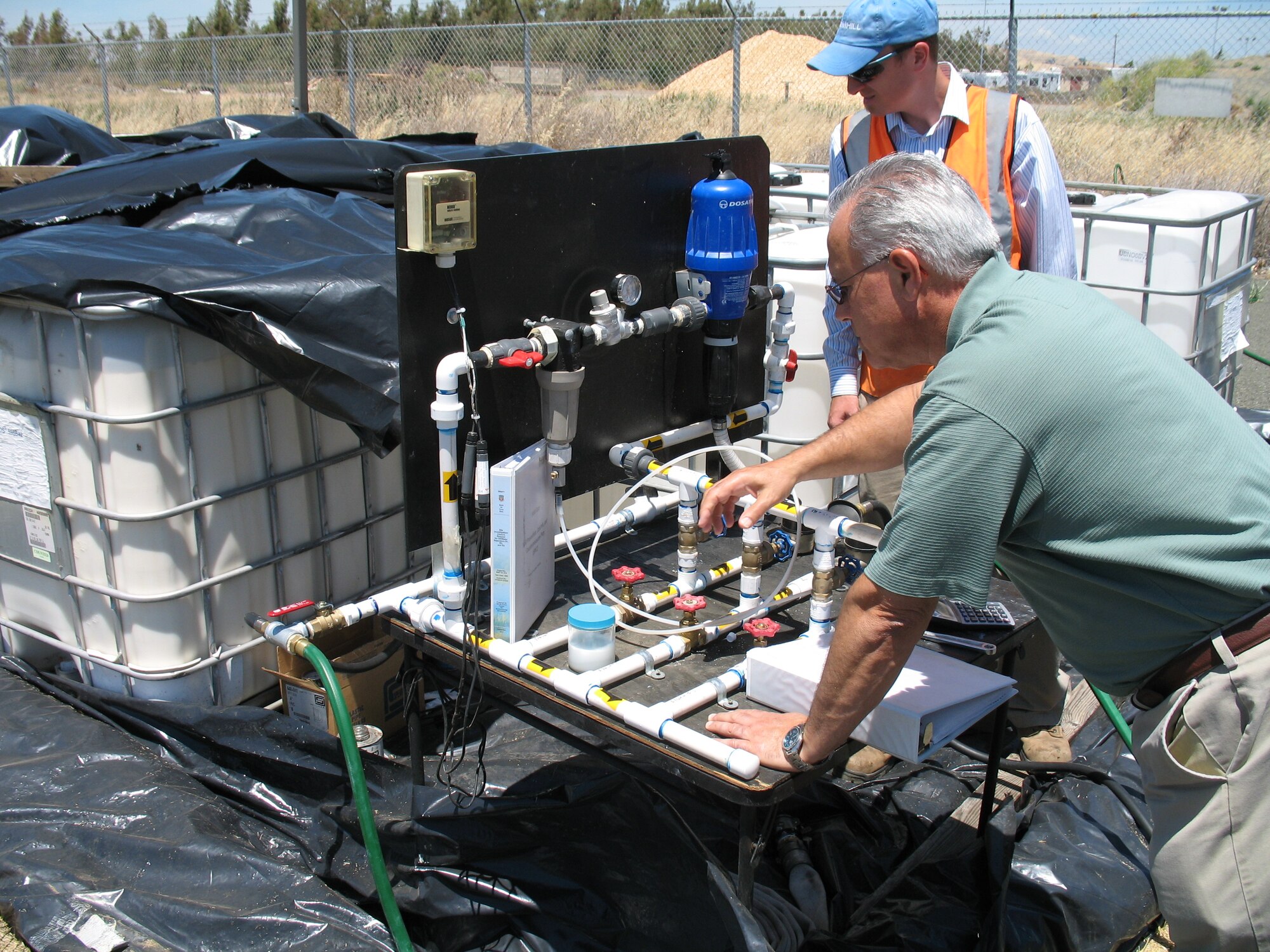 An Army Corps of Engineers representative inspects a valve assembly for pumping vegetable oil into injection werlls across a solvent plume. Microbes eat the oil, which promotes the break-down of solvent contaminants into harmless compounds.(Courtesy photo/Glenn Anderson)