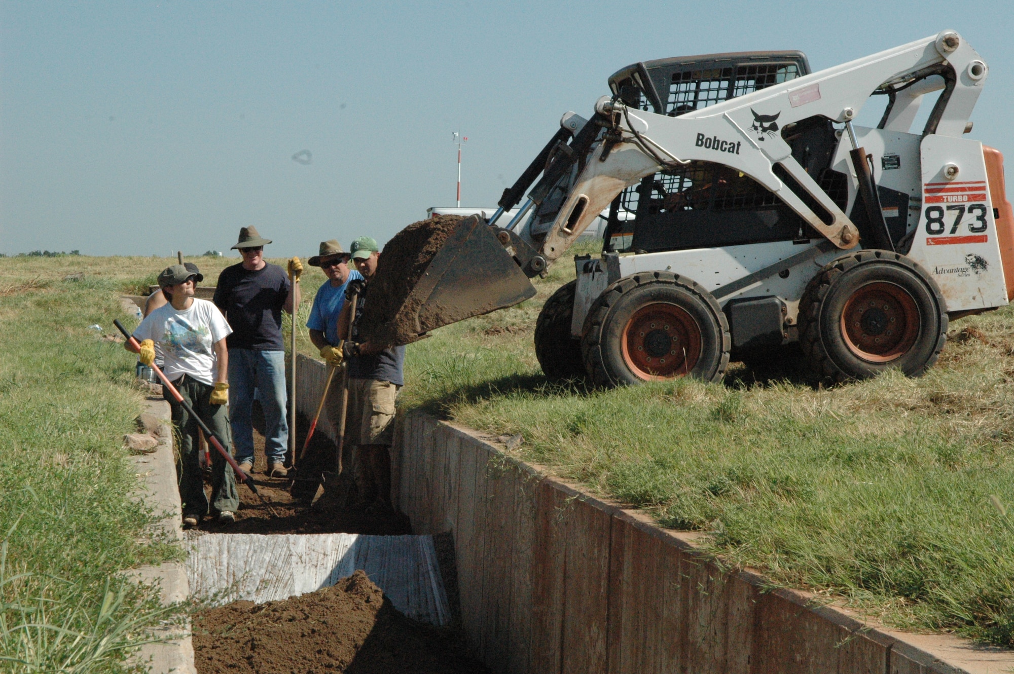 Environmental technicians from the 72nd Air Base Wing Civil Engineer Directorate install a dirt and grass bio-filter near Bldg. 3001 recently. The filter is meant to reduce zinc levels in the storm water run off. (Air Force photo by Brion Ockenfels)
