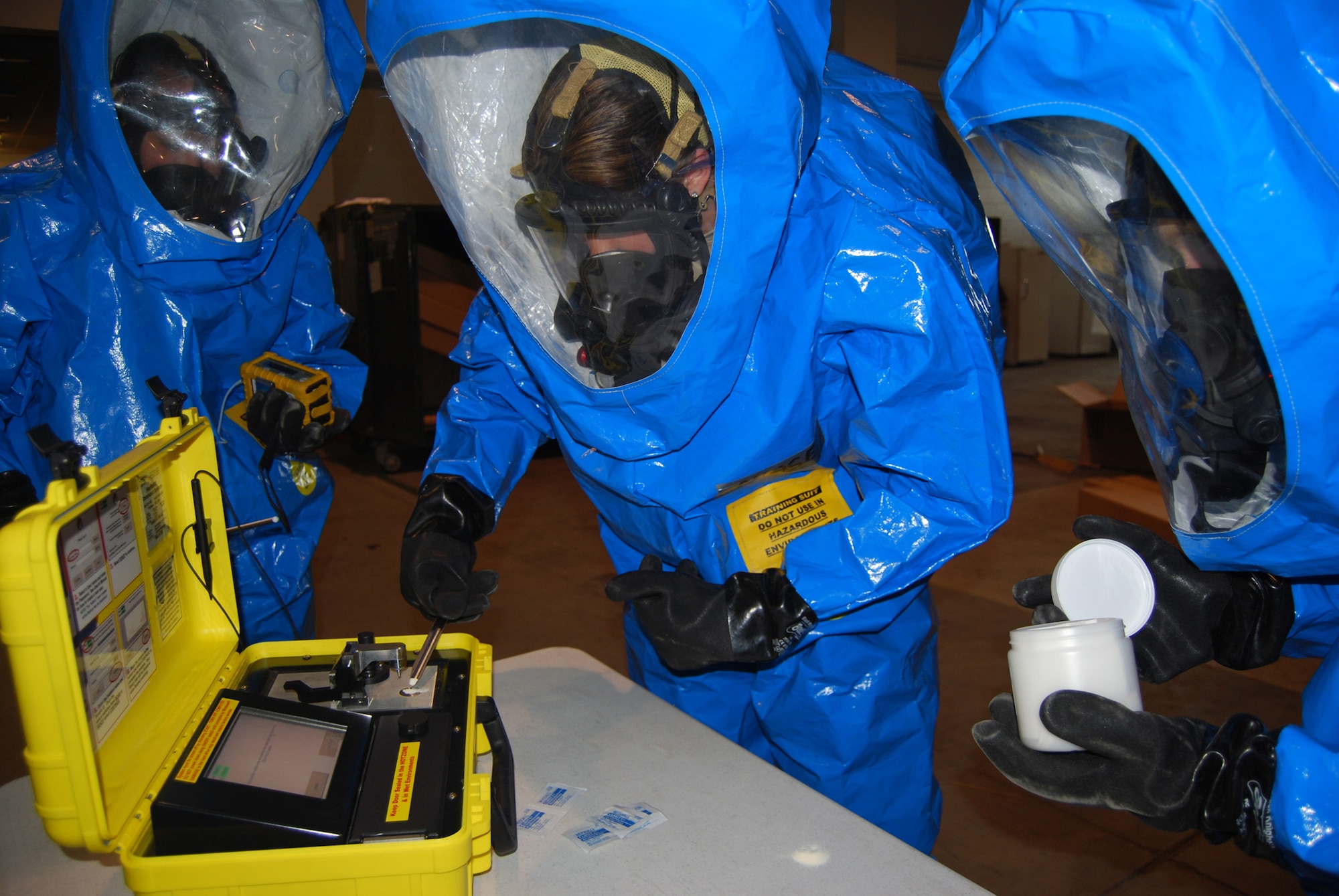 Senior Airman Rebecca Chase, 341st Civil Engineer Squadron emergency management technician, places an unknown powder on the HAZMAT ID, a detection device used by the CERF team to classify unidentified substances. Airmen 1st Class Brittany Musha and Michelle Smith assist in the process. (U.S. Air Force photo/Airman 1st Class Kristina Overton)