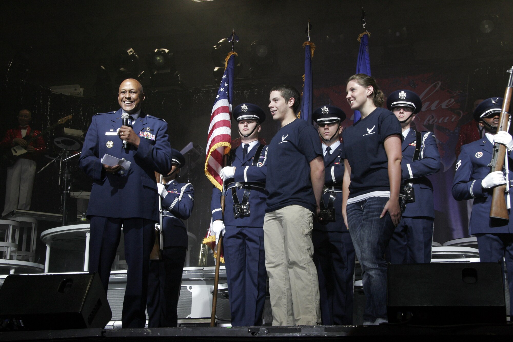 Col. Anthony Cotton, 341st Missile Wing commander, introduces Jonathan Osborn and Jordan Hanuschewicz, Air Force enlistees, to the crowd before leading the new recruits in an enlistment ceremony prior to the start of a Tops in Blue concert Aug. 11 at the Montana Expo Park. (U.S. Air Force photo/Senior Airman Dillon White)