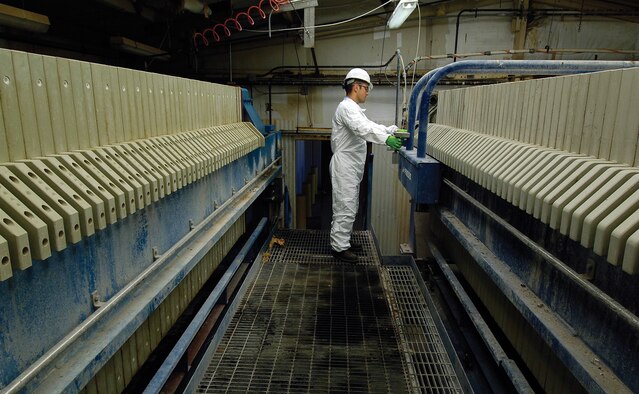 Industrial Waste Water Treatment Plant operator Nick Flynt will scrape dried industrial sludge from a plate and frame filter press that uses 3,500 pounds per square inch of pressure to remove water from the waste and dry it. Waste water from every Tinker shop flows to the IWTP, near the Hruskocy Gate, where it goes through several stages of cleaning and testing until it is clean enough to leave Tinker.