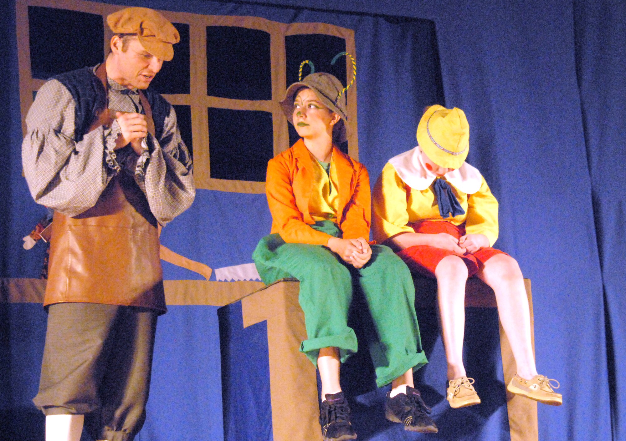 Geppetto, Brian Epperson, tells Jiminy Cricket, Amber Mantel, about his wish to have a son during this year's Missoula Children's Theatre Pinocchio play Aug. 21 at the base theater. Auditions for Pinocchio were held at the beginning of the week which cast 53 youths in grades K-12 into their roles. After rehearsing throughout the week, learning lines, songs and choreography, the youths performed two shows. (U.S. Air Force photo/Connie Hempel)
