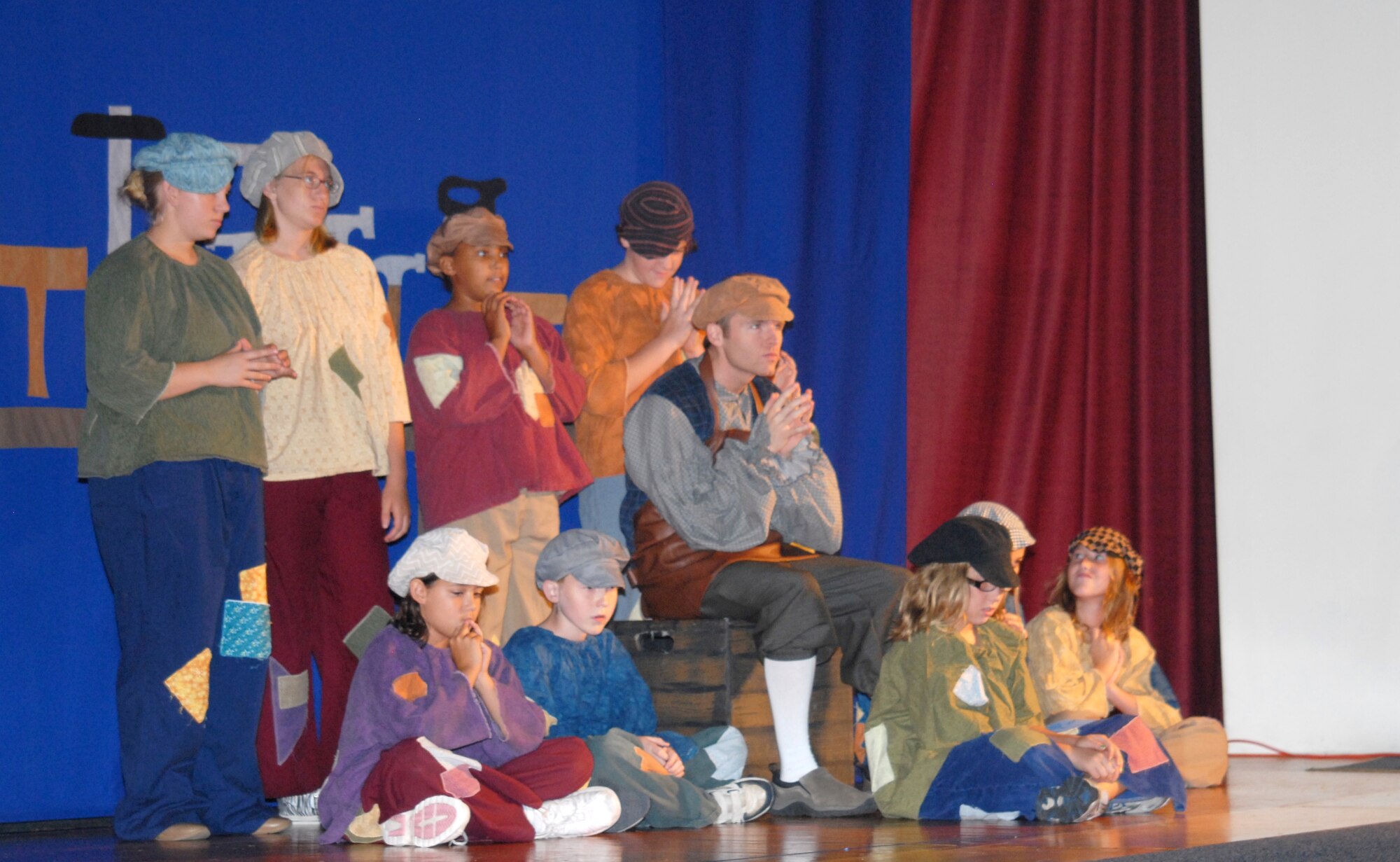 Urchins from the Pinoccio cast wait for Geppetto to tell his tale of Pinocchio during this year's Missoula Children's Theatre play Aug. 21 at the base theater. Auditions for Pinocchio were held at the beginning of the week which cast 53 youths in grades K-12 into their roles. After rehearsing throughout the week, learning lines, songs and choreography, the youths performed two shows. (U.S. Air Force photo/Connie Hempel)
