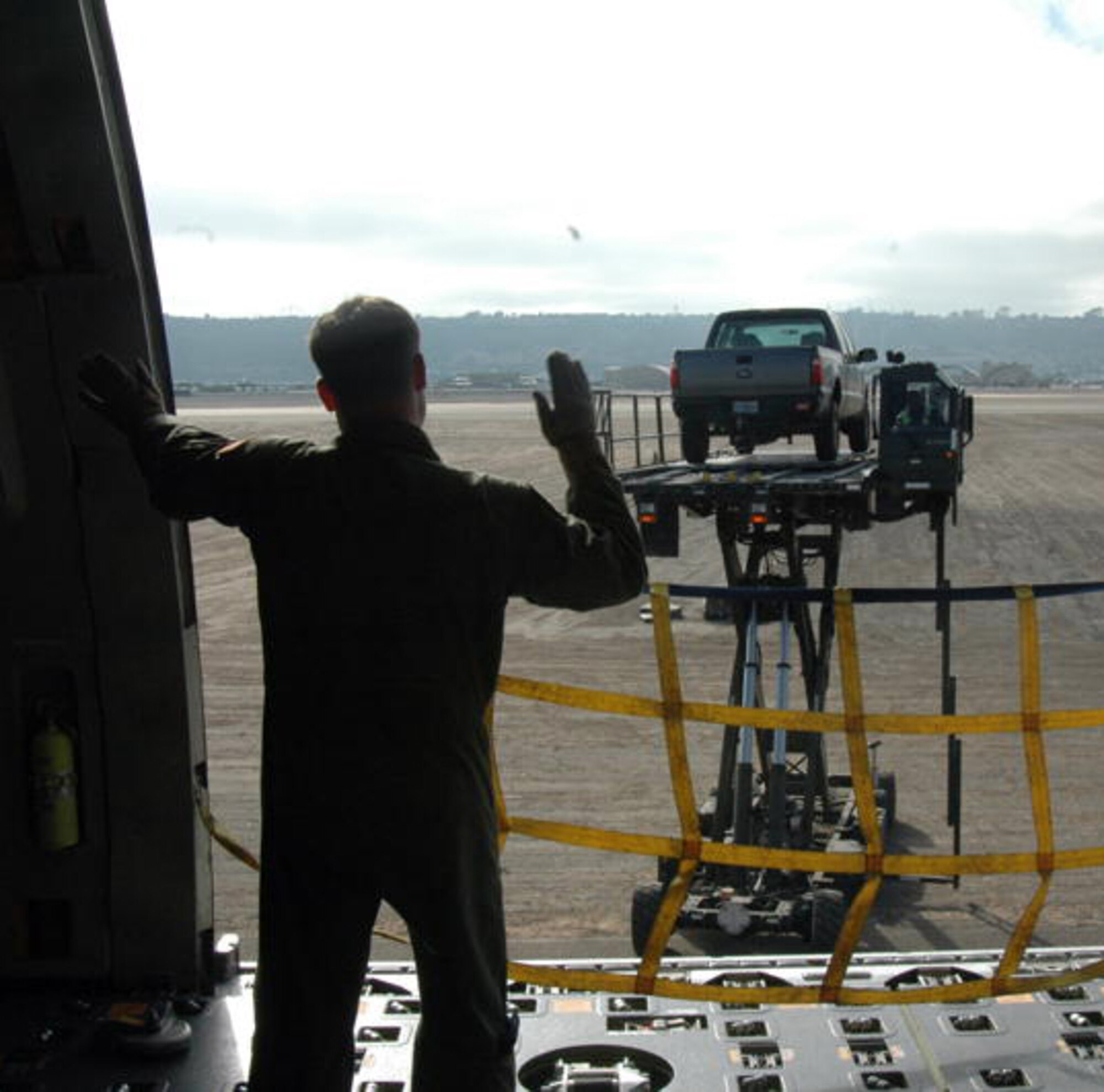 Staff Sgt. Stephen Wentz, 60th Operations Support Squadron KC-10 Extender formal training unit instructor guides the driver of a cargo loader as he loads a pickup truck onto a KC-10 at North Island Naval base Aug. 13. (U.S. Air Force photo/Staff Sgt.  Patrick Harrower)
