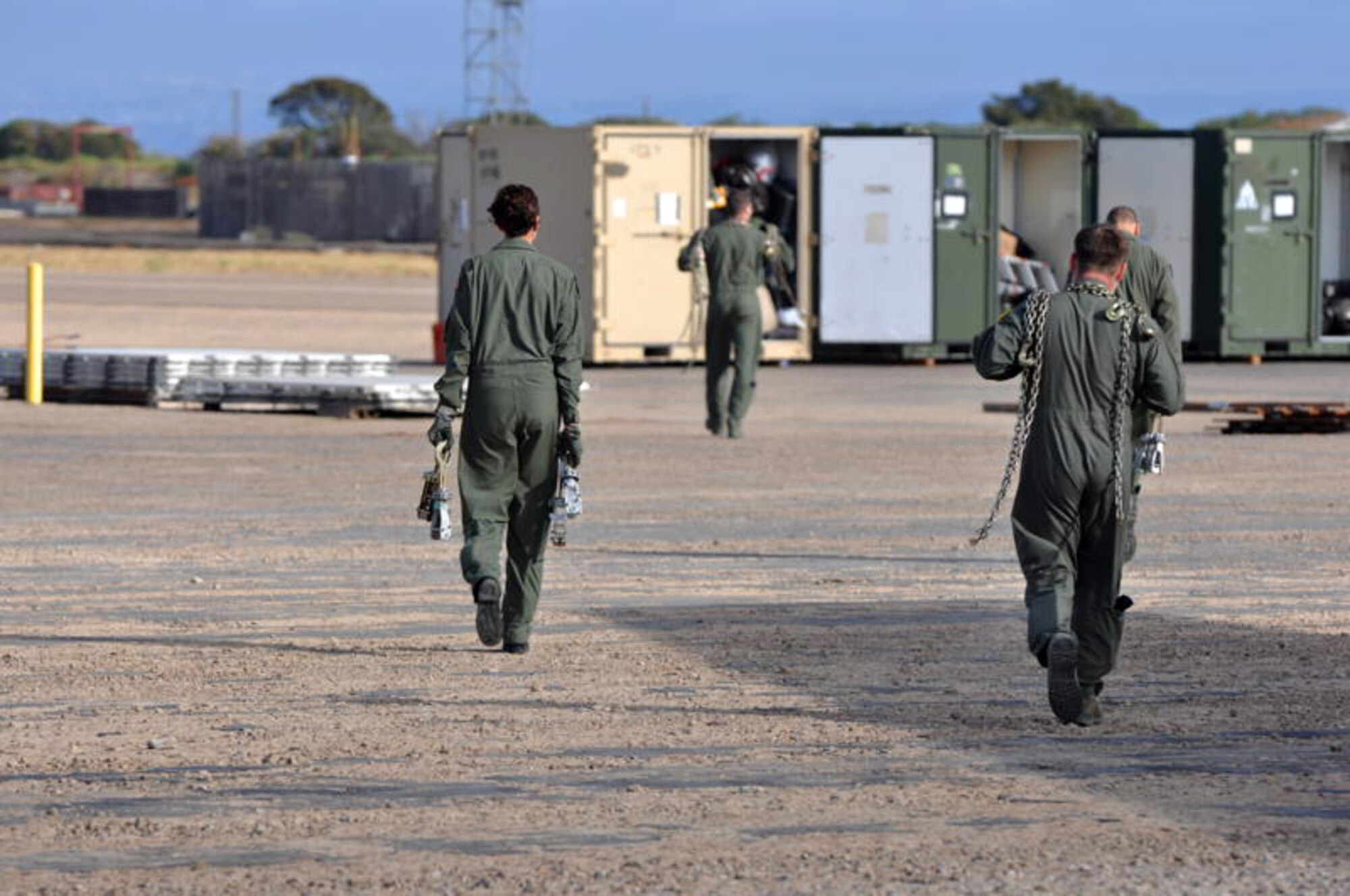 Airmen from the 60th Operations Support Squadron KC-10 Extender Formal Training Unit carry chains and devices to cargo boxes to help secure them at North Island Naval base Aug. 13 (U.S. Air Force photo/Staff Sgt.  Patrick Harrower)