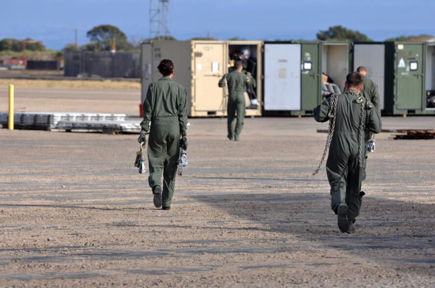 Airmen from the 60th Operations Support Squadron KC-10 Extender Formal Training Unit carry chains and devices to cargo boxes to help secure them at North Island Naval base Aug. 13 (U.S. Air Force photo/Staff Sgt.  Patrick Harrower)