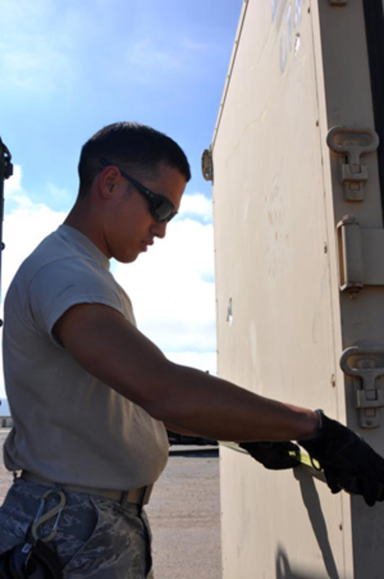 Senior Airman Jay Reynolds, 571st Global Mobility Squadron air transportation journeyman measures the dimensions of a cargo box at North Island Naval base Aug. 13 (U.S. Air Force photo/Staff Sgt.  Patrick Harrower)