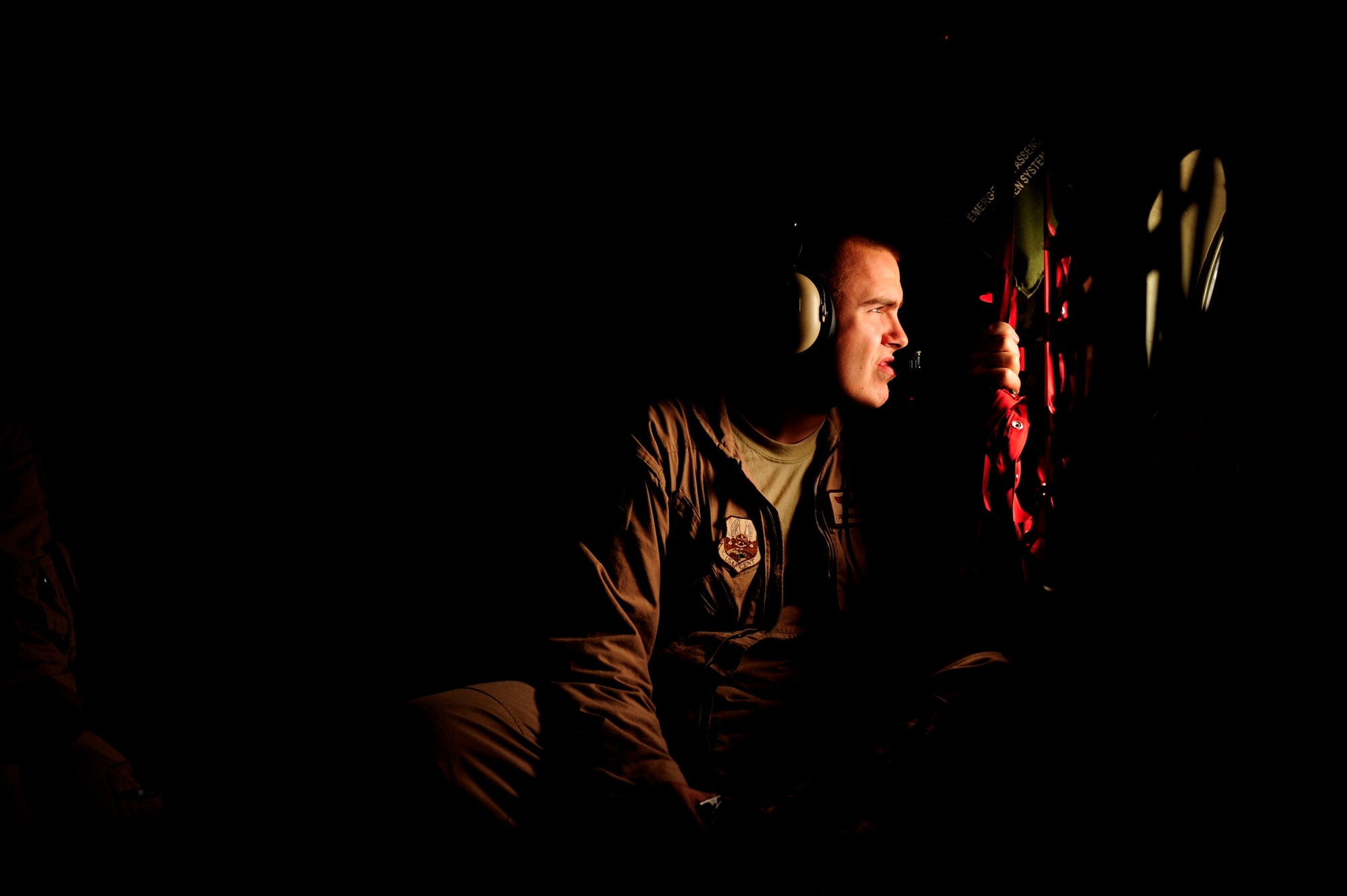U.S. Air Force Senior Airman Shon Manning, a C-130H Hercules loadmaster assigned to the 746th Expeditionary Airlift Squadron, scans out the window during a flying mission from Bagram Airfield, Afghanistan, to Pakistan in support of humanitarian relief efforts Aug. 20, 2010. (U.S. Air Force photo by Staff Sgt. Andy M. Kin/Released)