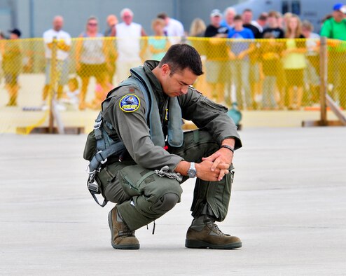 Viper East F-16 demo pilot, Maj. Ryan "Rider" Corrigan, takes a moment to collect his thoughts, or perhaps say a brief prayer, moments before his performance at the Volk Field Open House Saturday, Aug. 21. Flying high performance jet fighters is a dangerous business, even in peacetime. Fighter pilots must train and learn how to extract and exploit every ounce of performance from these supersonic weapons. A demo pilot's job is to extract this maximum performance on a regular basis, very close to the ground, sometimes under low cloud ceilings, and the margin for error is razor thin. (U.S. Air Force photo courtesy Joe Oliva) (RELEASED)
