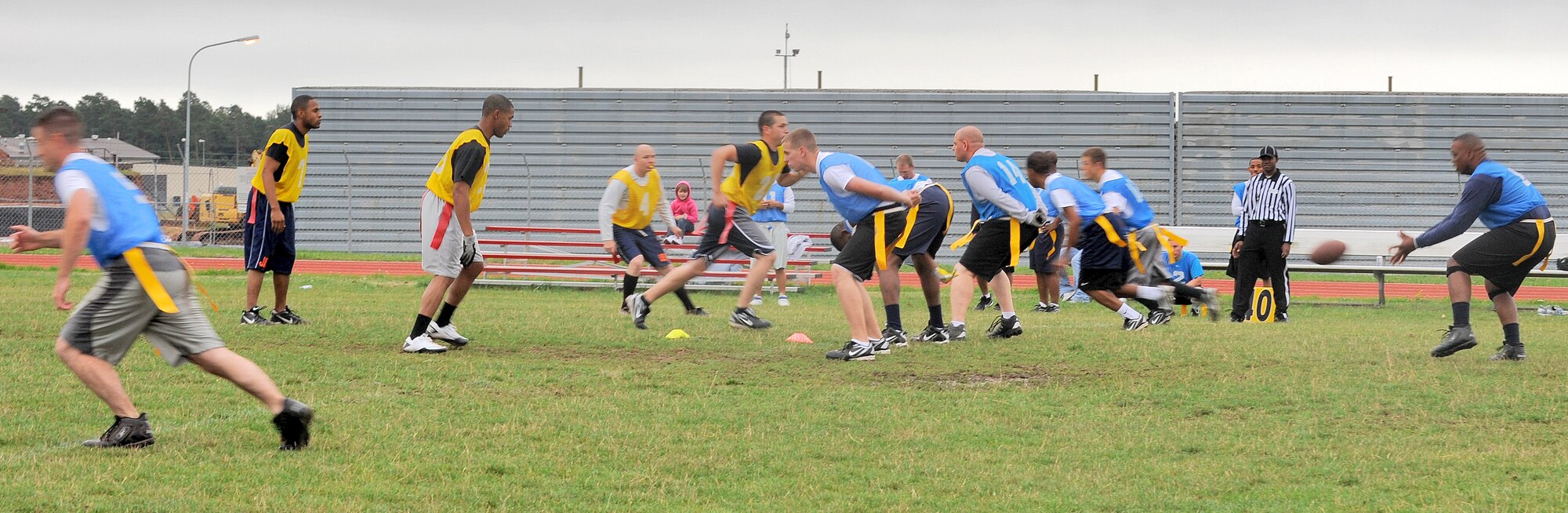SPANGDAHLEM AIR BASE, Germany - Benjamin Wynn, 726th Air Mobility Squadron intramural football team quarterback, snaps the ball as defenders from the 52nd Equipment Maintenance Squadron team attempt to prevent the 726th AMS from gaining yardage during a flag football game Aug. 16. The 726th AMS won with a score of 9-0. (U.S. Air Force photo/Senior Airman Nick Wilson)