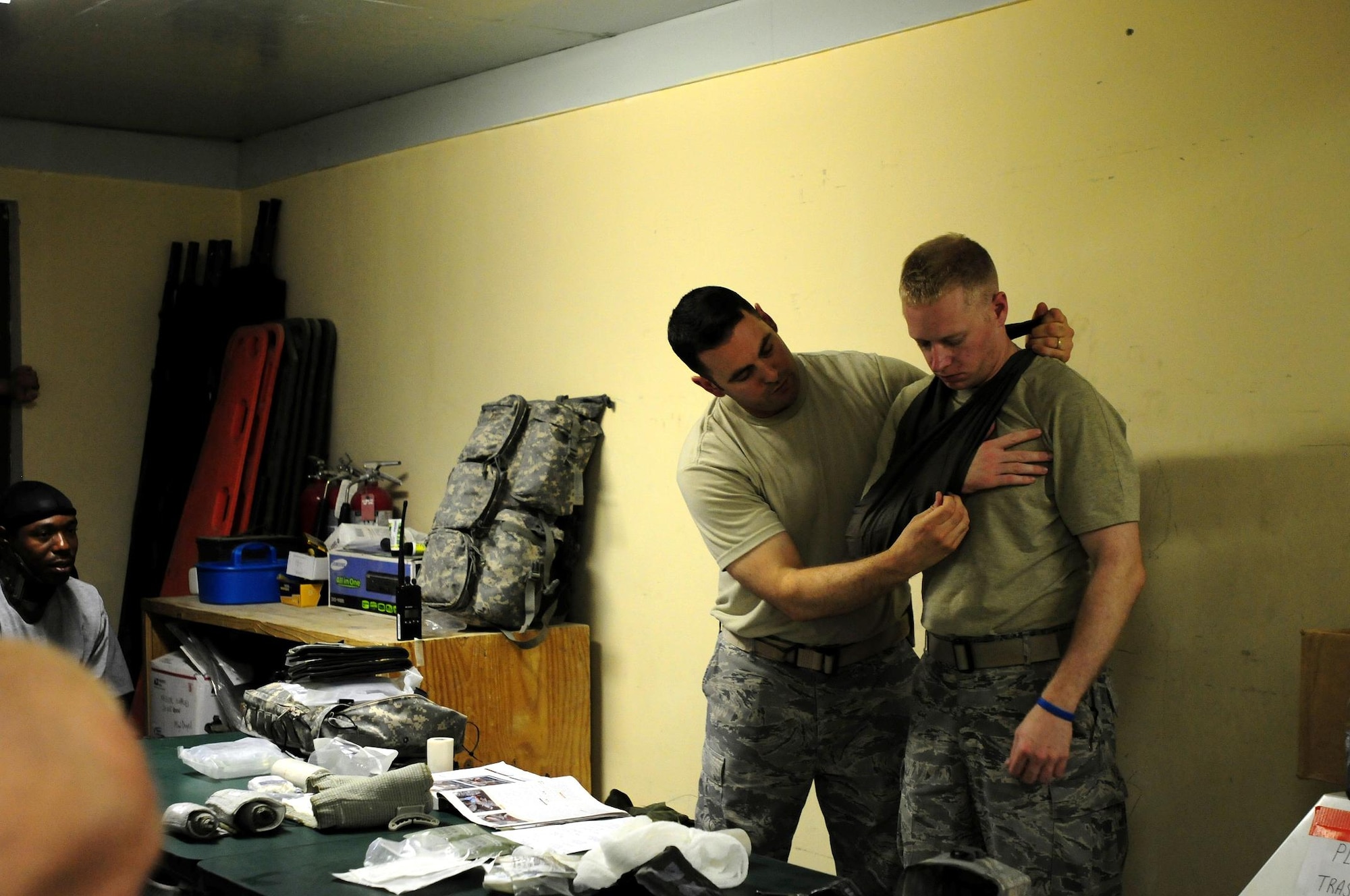 Laghman Provincial Reconstruction Team medics U.S. Air Force Master Sgt. Simon Deyell (left) and Senior Airman Jeffrey Marr demonstrate how to utilize a cravat as a sling during a Combat Lifesaver refresher course at the PRT barracks, Aug. 12, 2010. (U.S. Air Force photo by Staff Sgt. Ave I. Pele, Laghman Provincial Reconstruction Team Public Affairs)