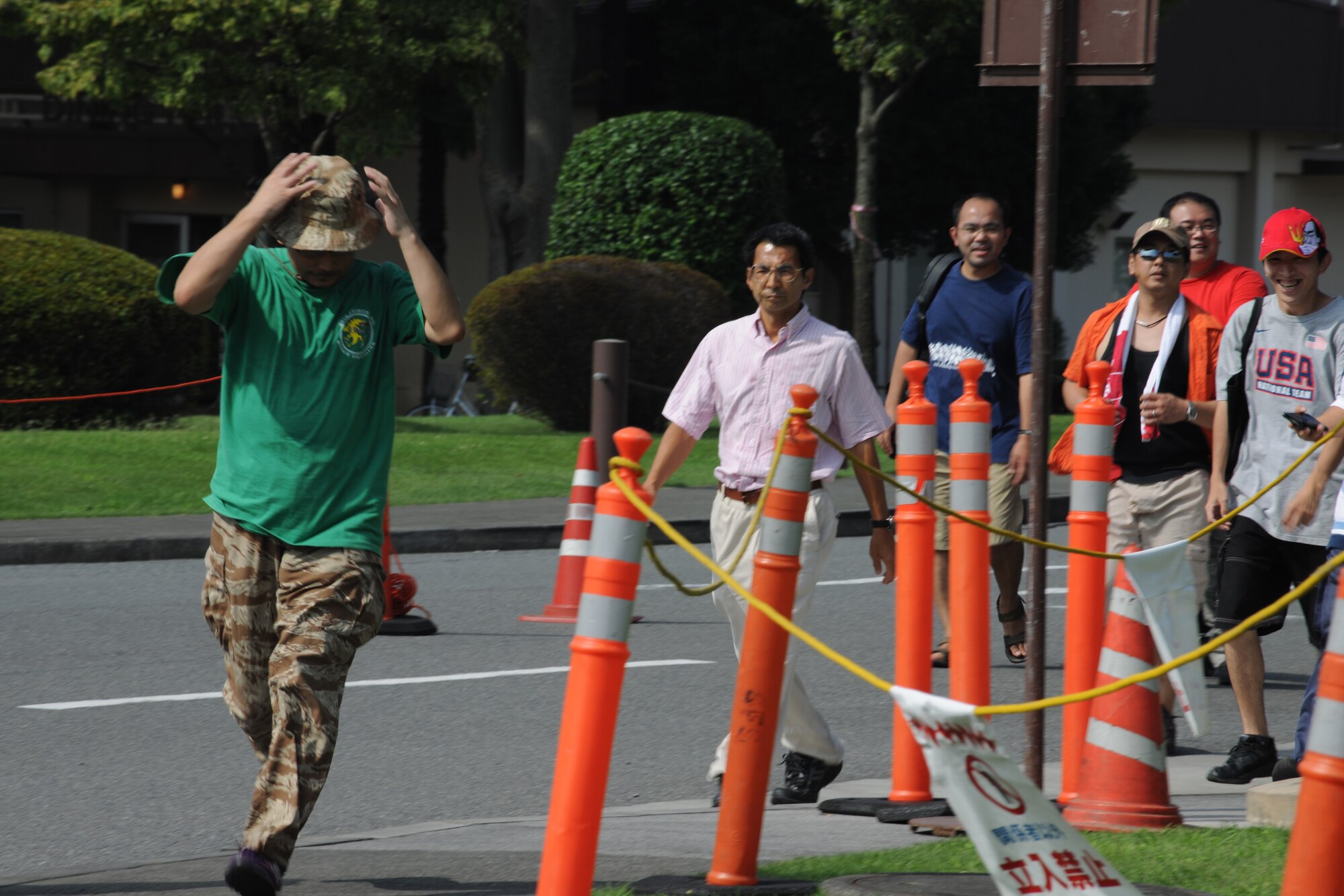 YOKOTA AIR BASE, Japan -- Local Japanese citizens run through the gates on opening day to be the first in line at Yokota's Friendship Festival.  More than 130,000 people attended the two-day 2010 Yokota Air Base Japanese-American Friendship Festival Aug. 21-22.  The base opened its gates to the public allowing Japanese citizens to get a glimpse of the base and interact with the Yokota community. The festival itself offered static displays, live music, games, and a variety of American and Japanese food items. The festival bolstered the bilateral relationship shared by the United States and Japan. (U.S. Air Force photo by Staff Sgt Stacy Moless)

