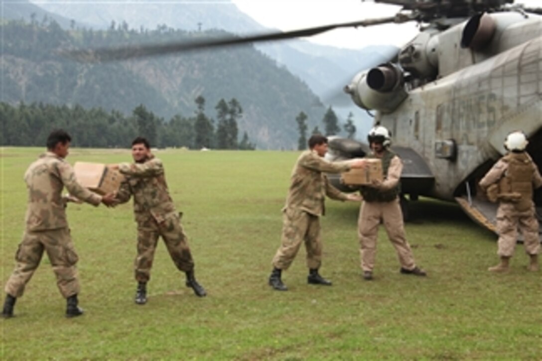 U.S. Marines assigned to Marine Medium Helicopter Squadron 165 and to the 15th Marine Expeditionary Unit help Pakistani soldiers unload supplies from CH-53E Super Stallion helicopters during humanitarian relief efforts in Khyber Pakhtunkhwa, Pakistan, on Aug. 17, 2010.  U.S. forces are partnering with the Pakistani military to coordinate relief efforts following heavy flooding in the region.  