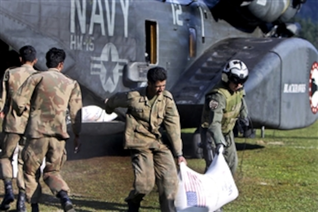 U.S. Navy sailors help Pakistani soldiers load relief supplies onto a U.S. Navy MH-53E Sea Dragon helicopter during humanitarian relief efforts in Pakistan's Khyber-Pakhtunkhwa province, Aug. 21, 2010. The sailors are assigned to Helicopter Mine Countermeasures Squadron 15.