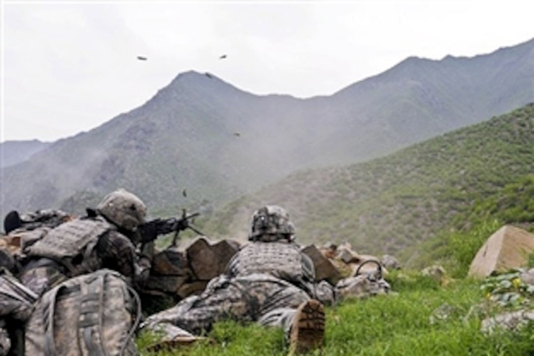 U.S. Army Spc. Brandon R. Romero and U.S. Army Staff Sgt. Glenn K. Luce open fire on a nearby building during an attack against troops visiting the village of Spinkay in eastern Afghanistan’s Kunar province, Aug. 18, 2010. The insurgents used mortars, small arms fire and rocket-propelled grenades against international and Afghan forces. Romero and Luce are assigned to Company A, 2nd Battalion, 327th Infantry Regiment.