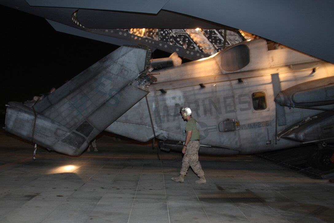 Master Sgt. William Gearhart, the maintenance chief for Marine Heavy Helicopter Squadron 361, 3rd Marine Air Craft Wing (Forward), monitors the clearance of a CH-53E Super Stallion as it is unloaded from an Air Force C-17 Globemaster III cargo plane Aug. 22. The Super Stallion is one of four that belongs to Marine Medium Tiltrotor Squadron 266 (Reinforced), 26th Marine Expeditionary Unit, that is preparing to support relief efforts in Pakistan.