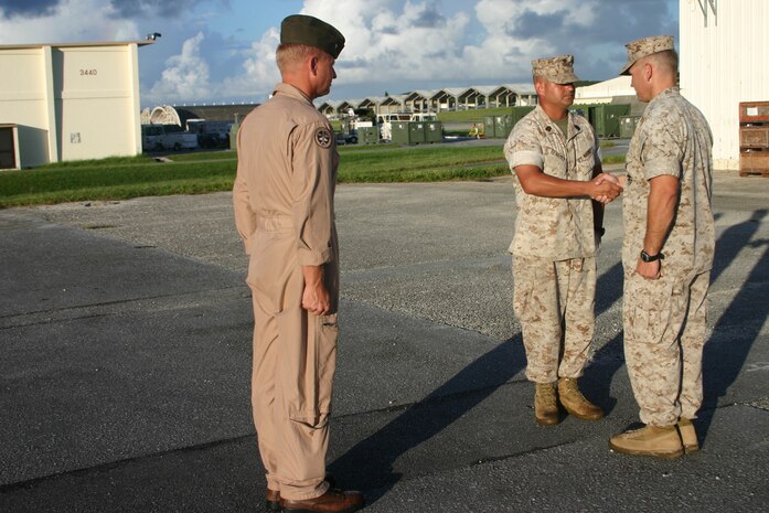 KADENA AIR BASE OKINAWA, Japan — Master Sgt. Rene Benedit, Marine All-Weather Fighter Attack Squadron 242 acting sergeant major, shakes hands with his incoming replacement, Sgt. Maj. Steven L. Brown, during a post-and-relief ceremony here Aug. 24.