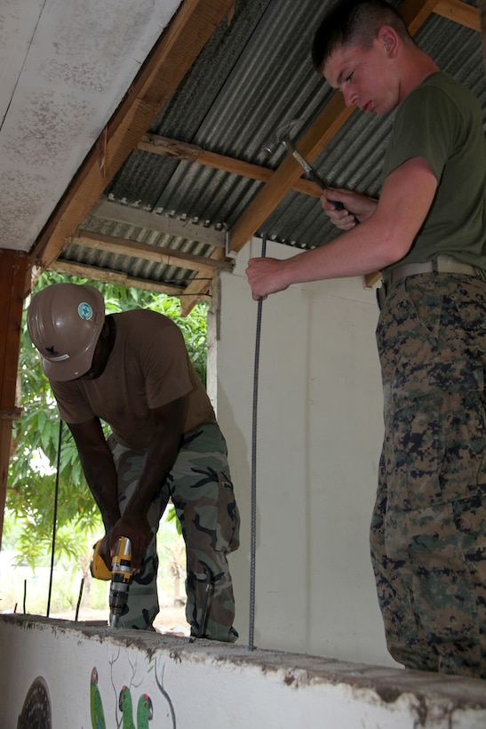 Pfc. Donald L. Cunningham, native of De Kalb Junction., N.Y., and bulk fuel specialist with 8th Engineer Support Battalion, Logistics Combat Element of Special-Purpose Marine Air-Ground Task Force Continuing Promise 2010, hammers rebar after Navy Combat Warfare Specialist 2nd Class Randall L. Johnson, native of Kansas City, Mo., drills holes into concrete during construction work an engineer site at the Center of Education and Nutrition in Bribri, Costa Rica, Aug. 24, 2010. Marines and Navy Seabees provided construction work at an engineer site to help Costa Ricans during CP10. Marines, sailors and USS Iwo Jima personnel are ported in Limon, Costa Rica, providing medical, dental, veterinary, community relations and engineering services to Costa Ricans as part of the CP10 mission during their deployment to the Caribbean, Central and South America.
