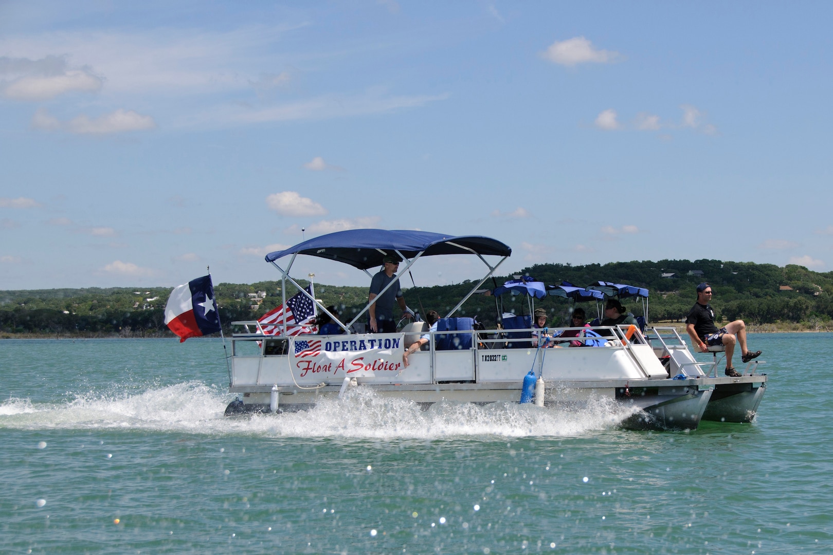 A boat carrying Wounded Warriors, their families and volunteers from the 559th Flying Training Squadron, Randolph Air Force base, Texas, heads for a barbeque lunch break during Operation Float a Soldier.  OFAS provides Wounded Warriors and their family members with a relaxing day of water activities and a barbeque lunch at Canyon Lake.  (U.S. Air Force photo/Steve Thurow)