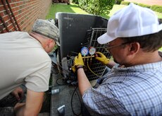 U.S. Air Force Airman Codye Miller and Craig Collins charge an air conditioning unit with nitrogen to 300 pounds per square inch to check for leaks Aug. 18, 2010, on Joint Base Charleston, S.C. Once the copper lines are filled with nitrogen, soapy water is sprayed on the brazed areas to check for leaks. Airman Miller and Mr. Collins are heating, ventilation and air conditioning technicians with the 628th Civil Engineer Squadron. (U.S. Air Force photo/Senior Airman Timothy Taylor)