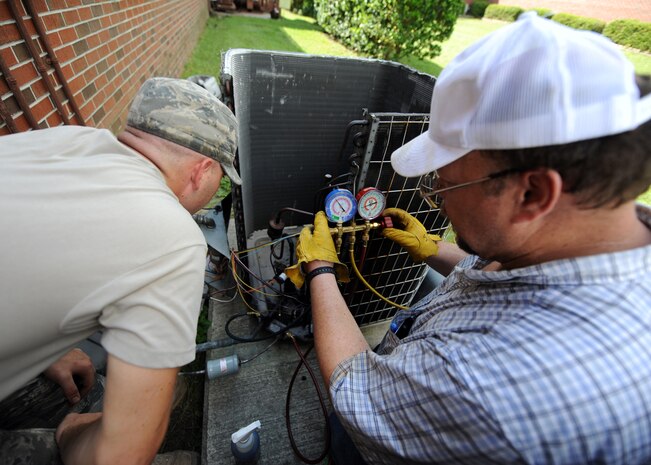 U.S. Air Force Airman Codye Miller and Craig Collins charge an air conditioning unit with nitrogen to 300 pounds per square inch to check for leaks Aug. 18, 2010, on Joint Base Charleston, S.C. Once the copper lines are filled with nitrogen, soapy water is sprayed on the brazed areas to check for leaks. Airman Miller and Mr. Collins are heating, ventilation and air conditioning technicians with the 628th Civil Engineer Squadron. (U.S. Air Force photo/Senior Airman Timothy Taylor)