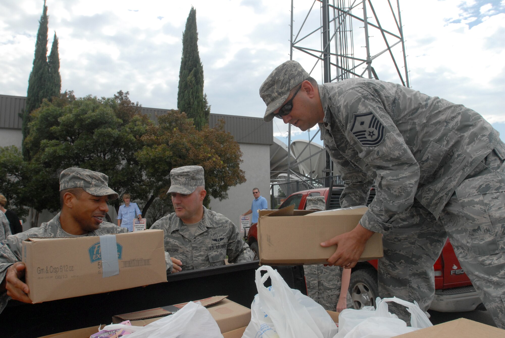 Master Sgt. Thadius Sankey, Master Sgt. Chad Madore, and Master Sgt. Robert VanCamp load up a pickup bed with donated items at a local television station Aug. 18.  Supplies were collected by several local agencies and donated to the Goodfellow First Sergeant Council.  The donated items will be made into care packages and be sent to individuals deployed in Iraq or Afghanistan. (U.S. Air Force photo/Master Sgt. Randy Mallard)