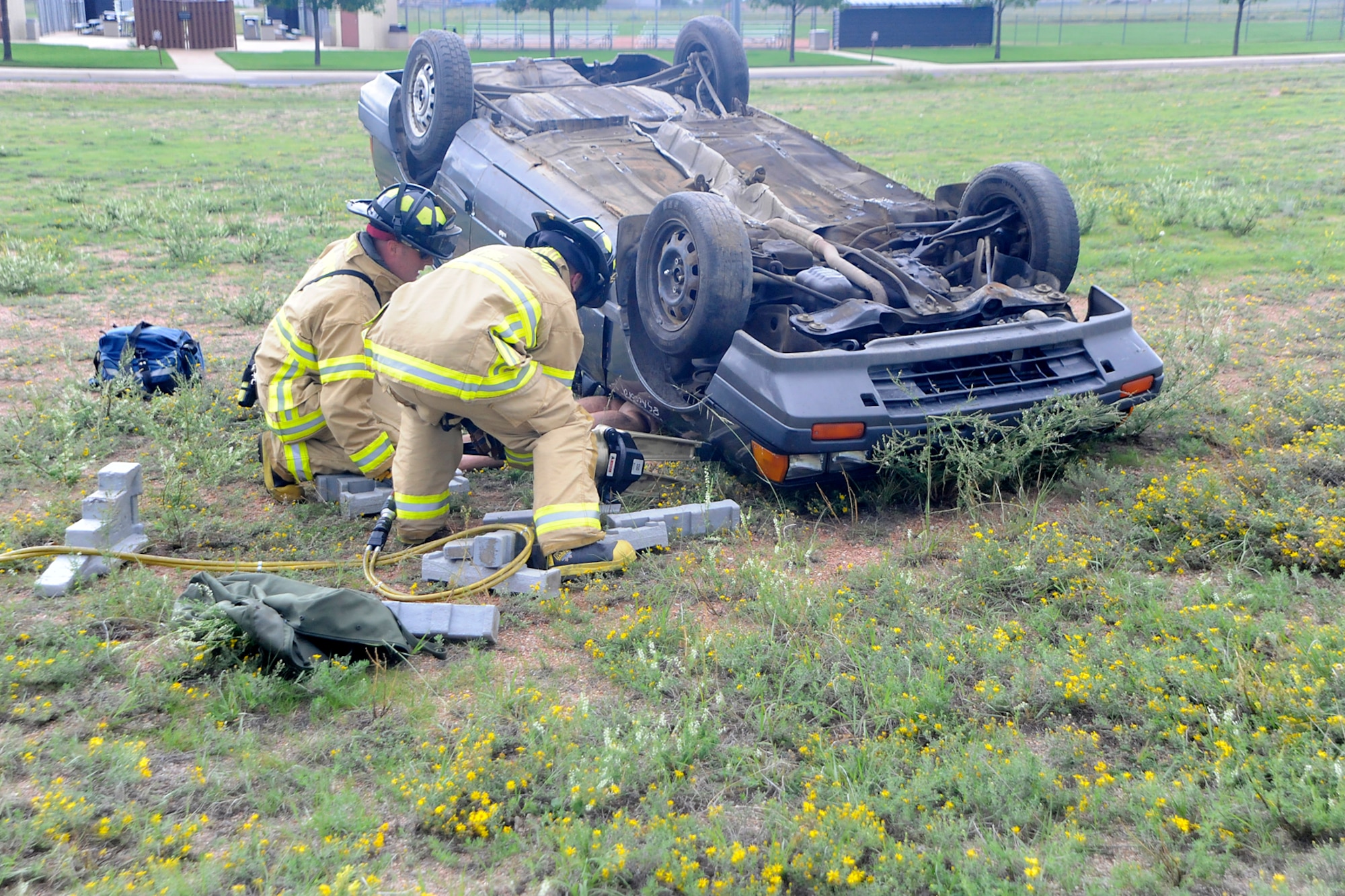 21st Space Wing firefighters respond to a trapped person under a flipped car during a tornado scenario in the quarterly Condor Crest exercise on Peterson Air Force Base Aug. 16 to 20. Firefighters used a hydraulic rescue tool, also known as the “jaws of life,” to peel back the metal of a smashed car so they could safely extract an injured driver. The exercise tested emergency response to a large-scale natural disaster. (U.S. Air Force photo/Dennis Howk)