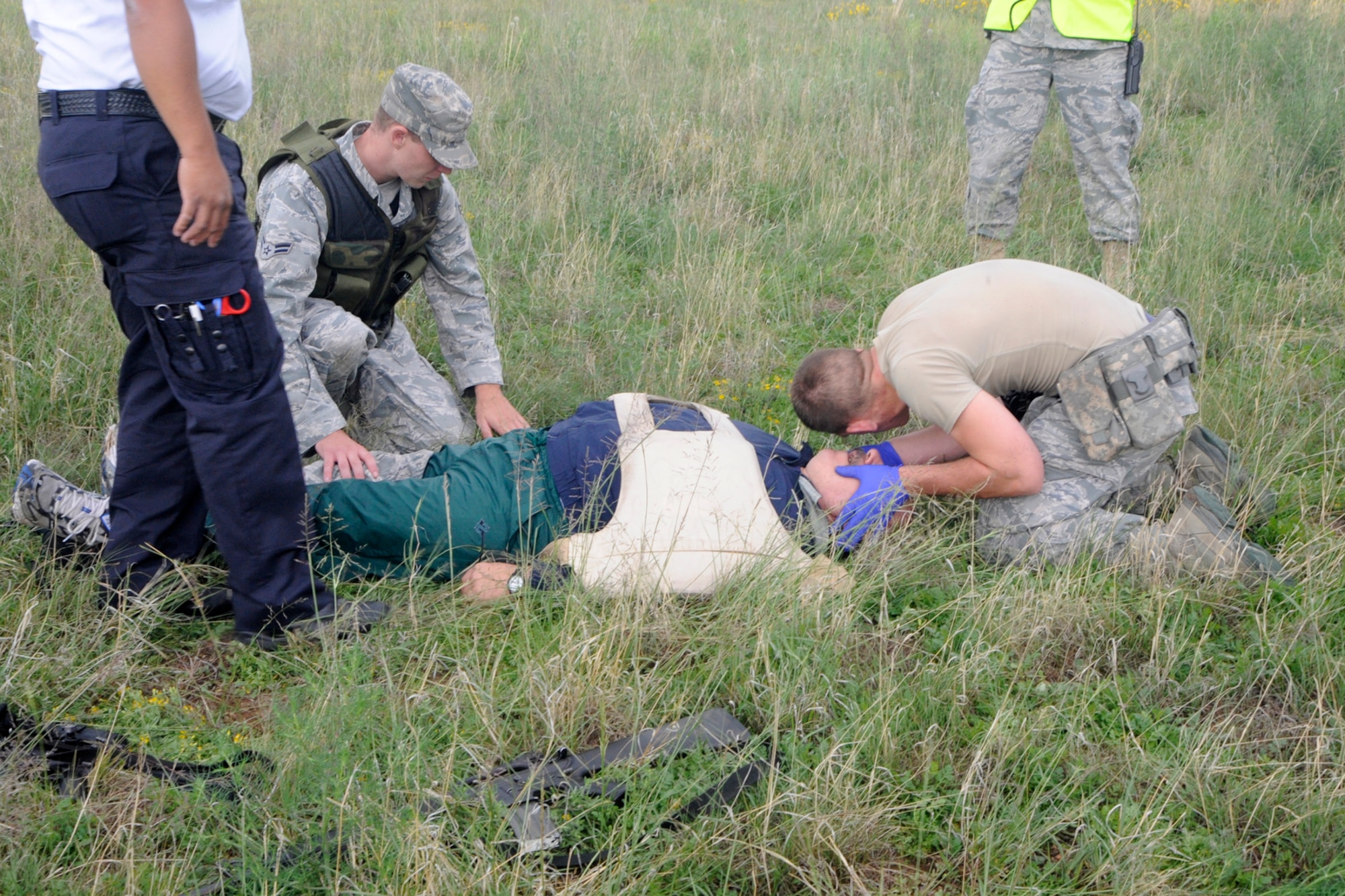 First responders render CPR to a tornado victim during a quarterly Condor Crest exercise on Peterson Air Force Base Aug. 16 to 20. In the scenario, a tornado whipped through the north side of the base, leaving more than 30 people injured and scattered through the ball fields. The exercise was an opportunity for Peterson emergency responders to practice response to a natural disaster and work with outside agencies, including the Flight for Life emergency helicopter transport, the Colorado Springs Emergency Operation Center and the Colorado Springs 911 call center. (U.S. Air Force photo/Dennis Howk)