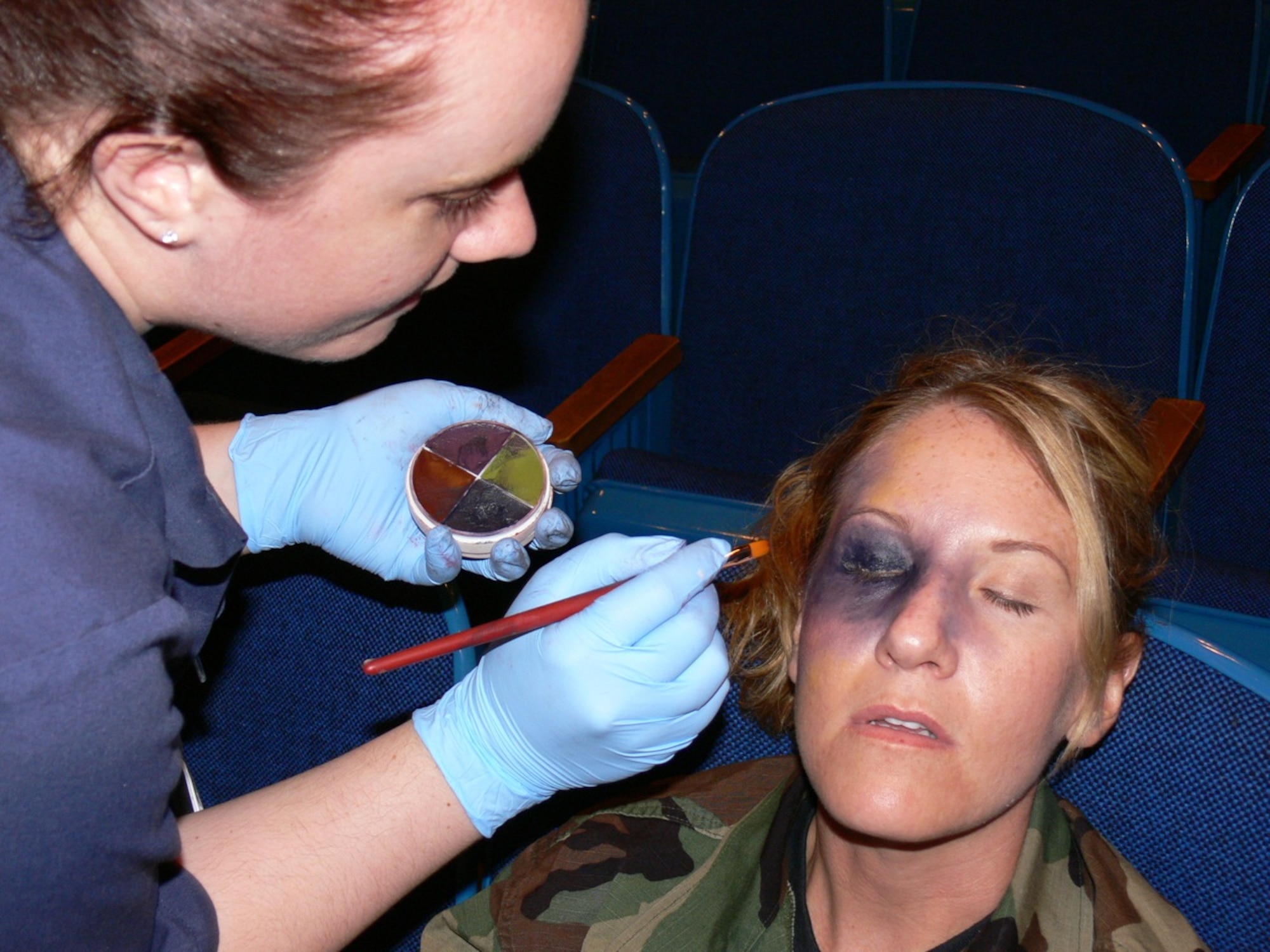 Staff Sgt. Marie Thomas, 21st Dental Squadron, paints Master Sgt. Tina Timmerman’s face in preparation for Condor Crest quarterly exercise on Peterson Air Force Base Aug. 16 to 20. Sergeant Timmerman played a tornado victim in an exercise that tested emergency response to a natural disaster. Preparation for the five-day exercise began in July and had 174 events, more than 50 role players, and more than 80 Exercise Evaluation Team inspectors . Members of the 21st Dental Squadron applied moulage makeup and bandages to 30 victims for the tornado scenario. (U.S. Air Force photo/Monica Mendoza)