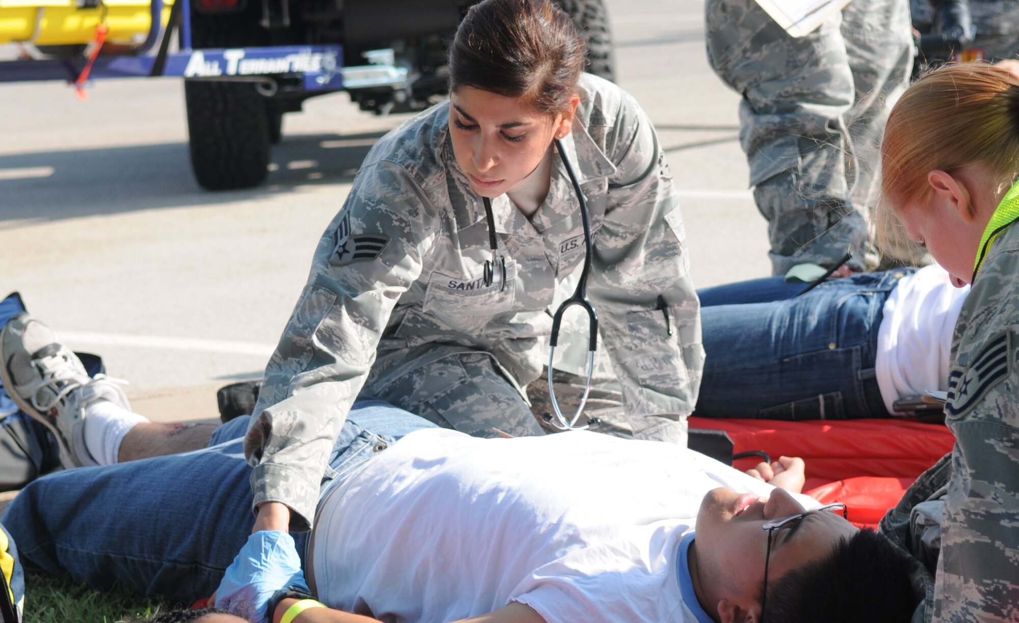 Senior Airman Tabbatha Santana, 17th Medical Operations Squadron, checks vitals of a victim outside the Carswell Field House while Staff Sgt. Jessi Smith, 17th Medical Support Squadron, fills out his patient record during the active shooter exercise Aug. 19. (U.S. Air Force photo/Airman 1st Class Clayton Lenhardt)