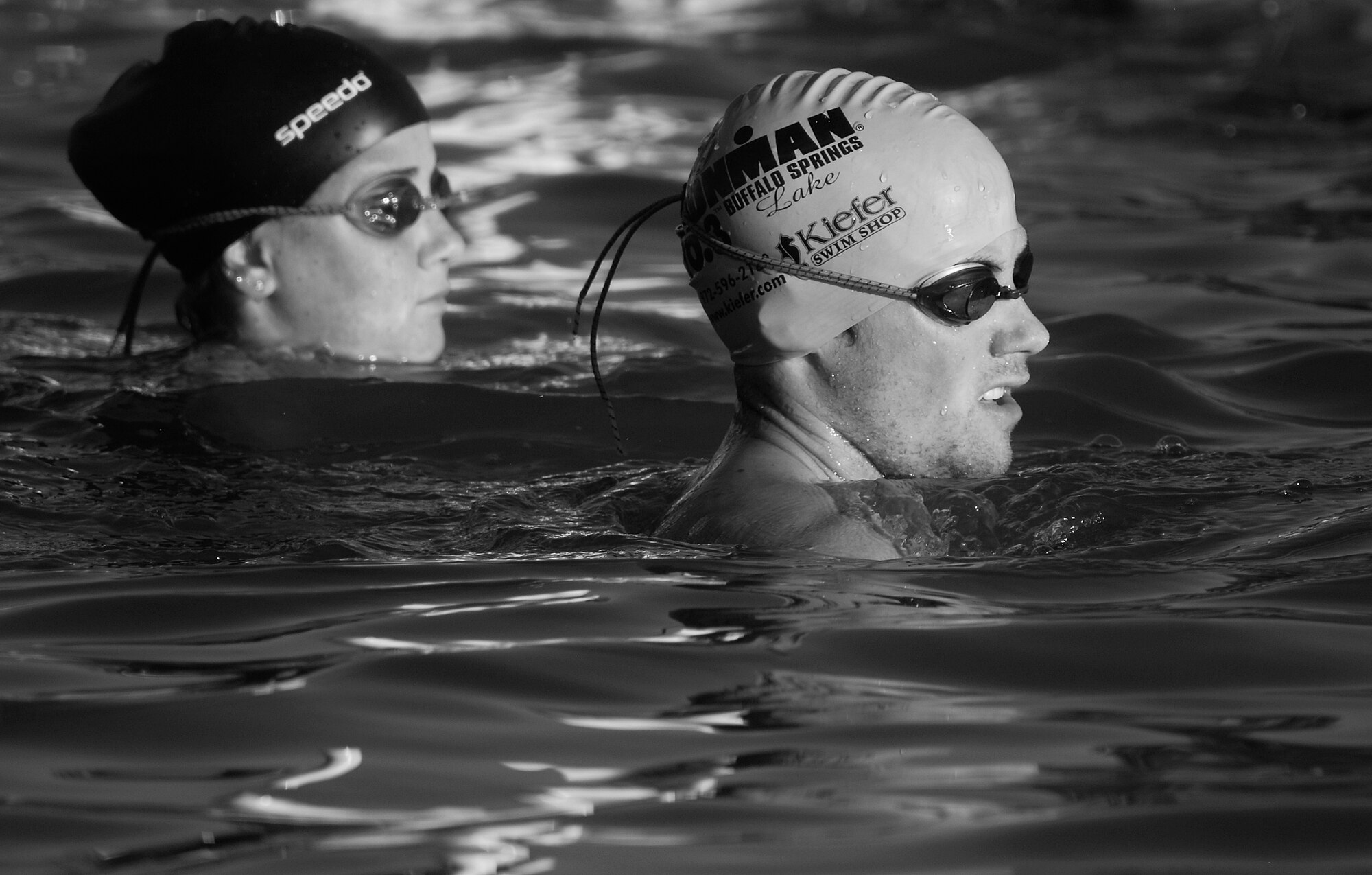 Two competitors wait for the “wet” start of the 400-meter swim during the 2010 Triathlon Aug. 21.  The triathlon, open to military and the community, was comprised of a 400-meter swim, 20-kilometer bike ride, and a 5-kilometer run.  (U.S. Air Force photo/ Master Sgt Randy Mallard)