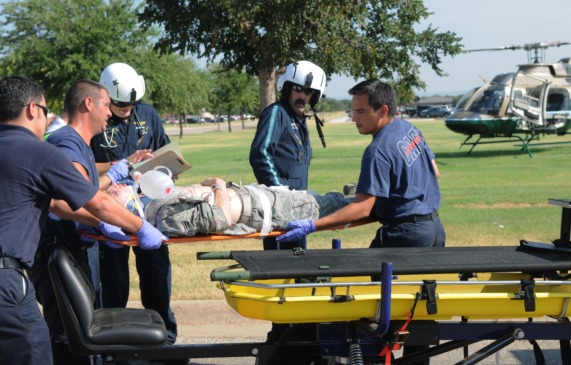 Goodfellow Air Force Base firefighters Christopher Mora, Bill Prorencal and Miguel Chacon get ready to load a victim onto the Shannon AirMed while Cody Snodgrass, Shannon AirMed registered nurse/paramedic looks over details and Sean McCallum, Shannon AirMed paramedic, leads the way during the active shooter exercise Aug. 19. (U.S. Air Force photo/Connie Hempel)