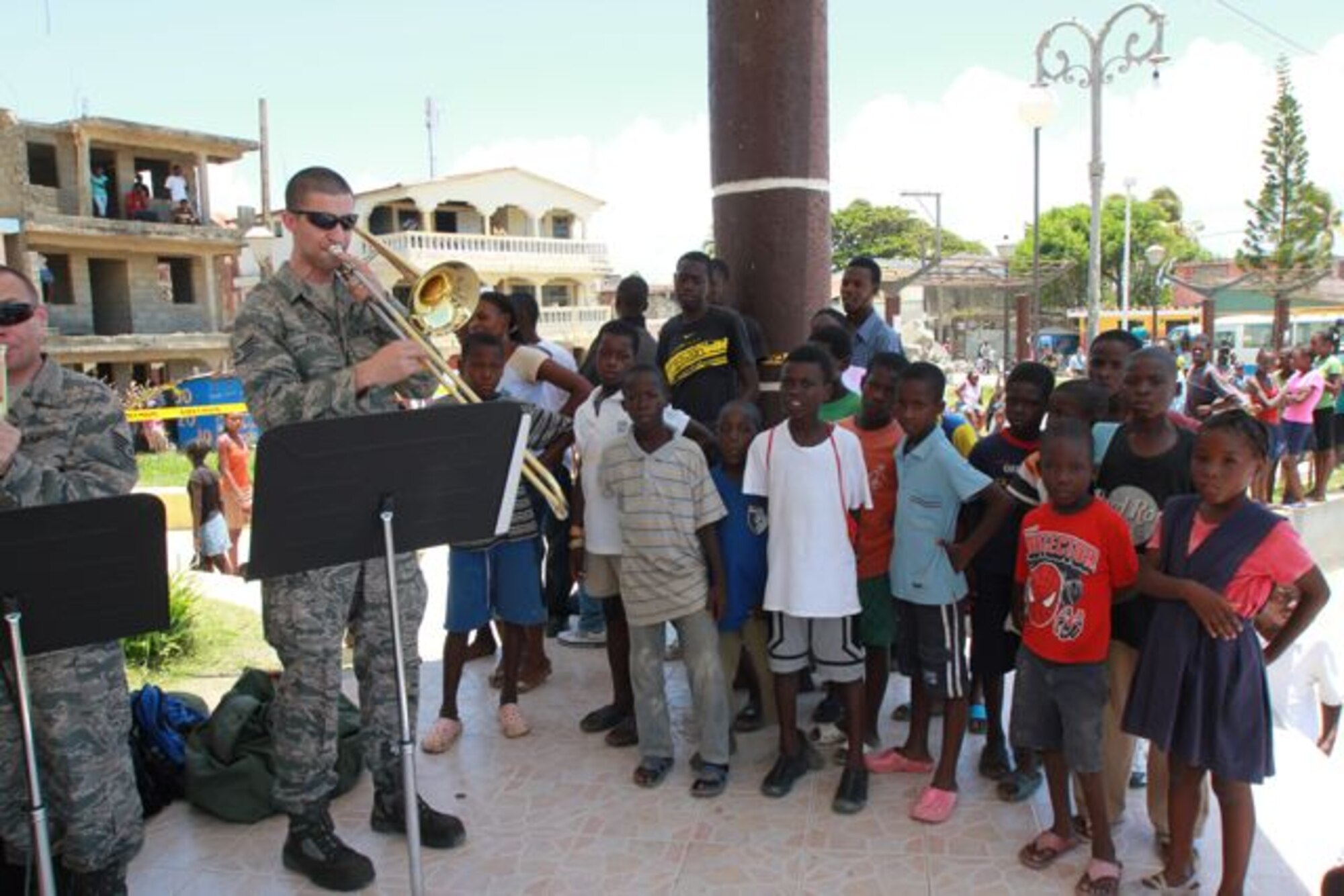 Staff Sgts. Scott Wise (from left) and Doug Kost are shown performing for local Haitian children as part of New Harmony, the United States Air Force Band of Flight’s newest ensemble deployed in support of a United States Southern Command humanitarian mission. The group departed in July for a 120-day deployment. (Courtesy photo)