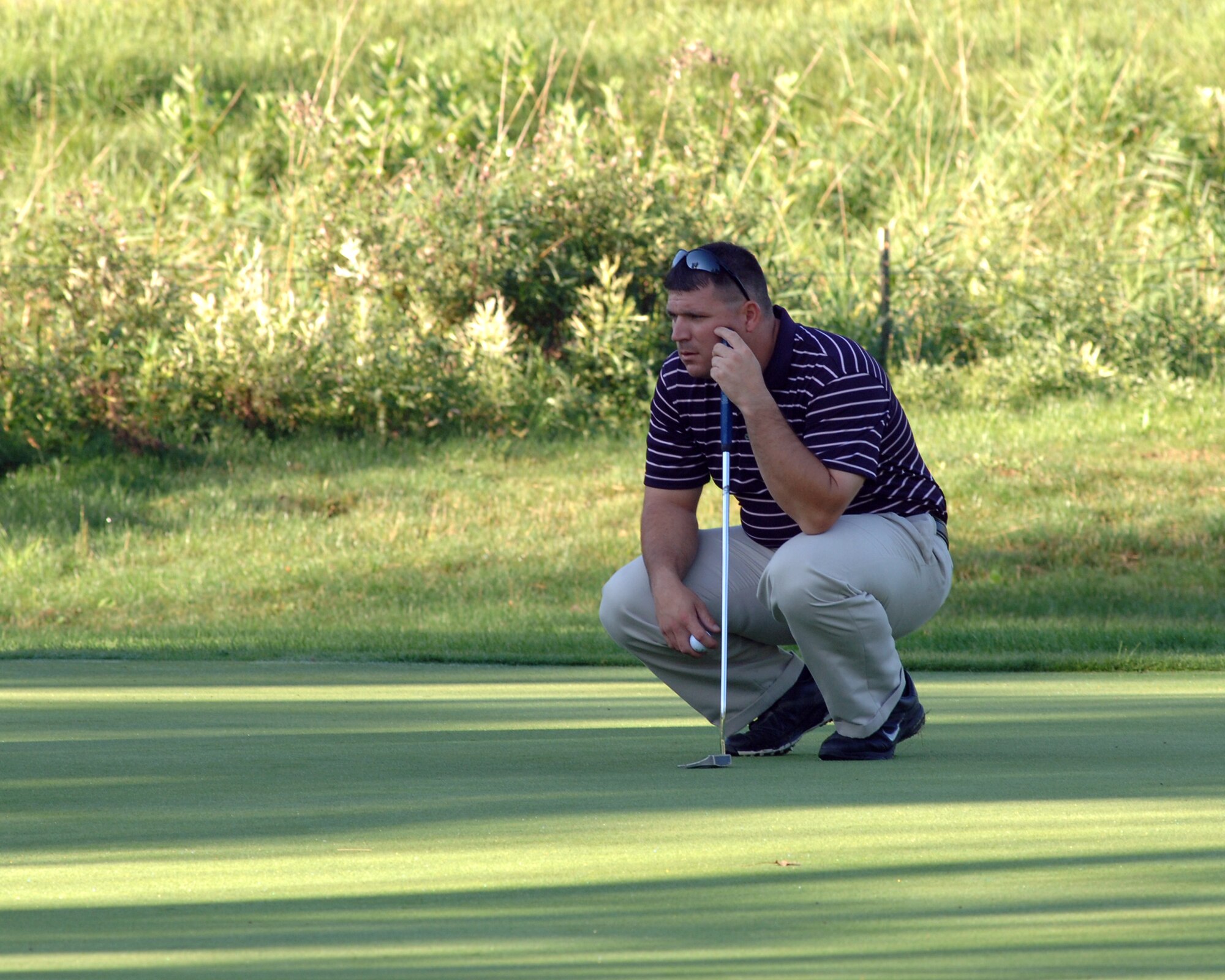 Staff Sgt. Stephen W. Smith, Area Defense Counsel, contemplates his upcoming putt Aug. 23 in Battle Lake, Minn. Sergeant Smith, and two other Grand Forks Air Force Base Airmen, traveled to Minnesota to take the Professional Golf Association’s Players Ability Test at Balmoral Golf Course. To pass the PGA’s test, players had to finish 36 holes of golf with a score of 153 or less. (U.S. Air Force photo by Staff Sgt. R. Michael Longoria)