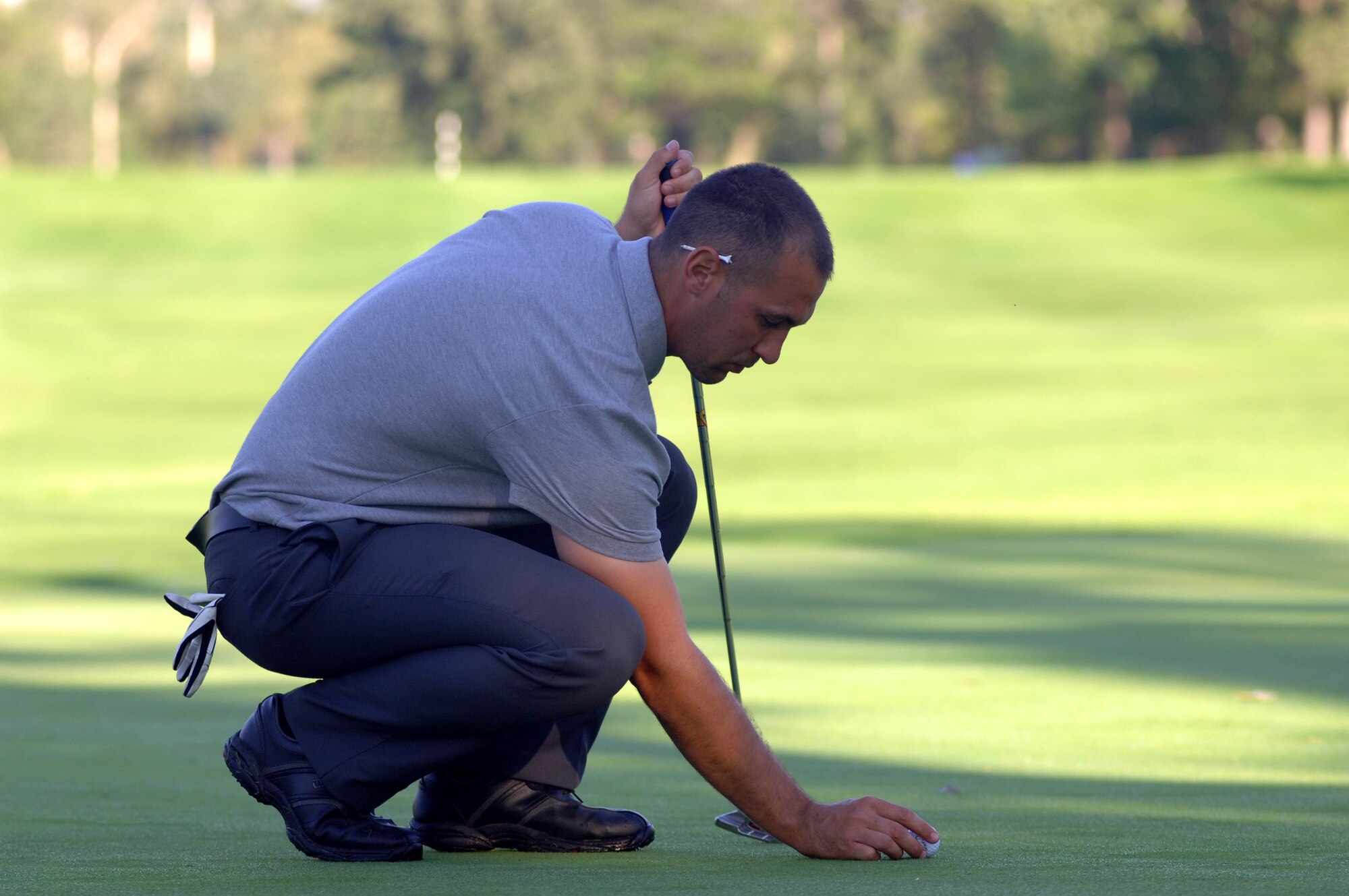 Senior Airman Johnathon A. Jones, 319th Civil Engineer Squadron, places his ball on the green Aug. 23 in Battle Lake, Minn. Airman Jones, and two other Grand Forks Air Force Base Airmen, traveled to Minnesota to take the Professional Golf Association’s Players Ability Test at Balmoral Golf Course. To pass the PGA’s test, players had to finish 36 holes of golf with a score of 153 or less. (U.S. Air Force photo by Staff Sgt. R. Michael Longoria)