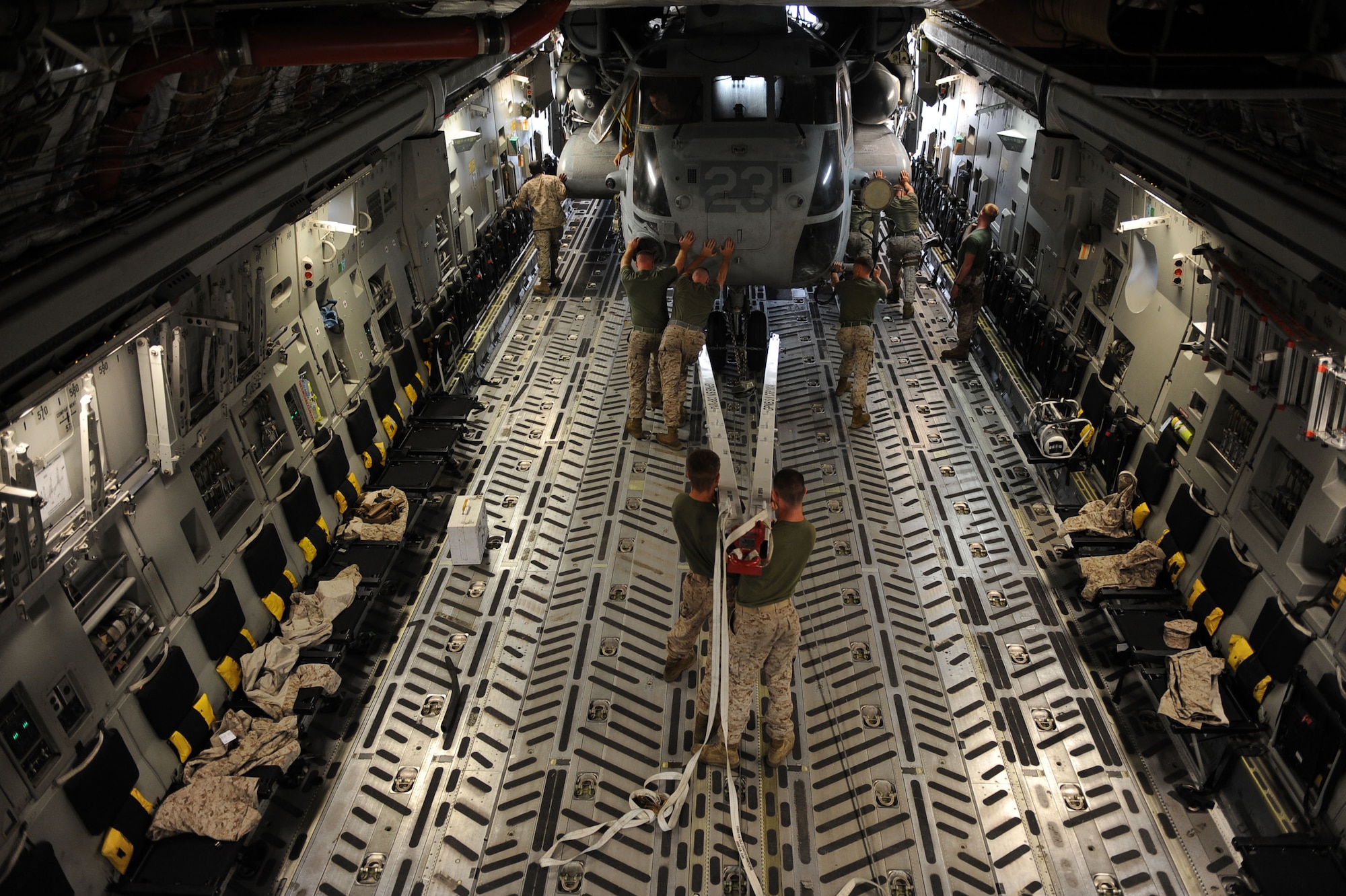14th Airlift Squadron loadmasters and U.S. Marines assigned to the 266th Medium Tilt Rotor Squadron, unload a U.S. Marine Corps MH-53E Super Stallion out of the cargo area of a C-17A aircraft, Aug. 23, 2010 at Camp Bastion, Afghanistan. The mission is in support of the Pakistan flood relief efforts. (U.S. Air Force photo/Staff Sgt. Manuel J. Martinez)